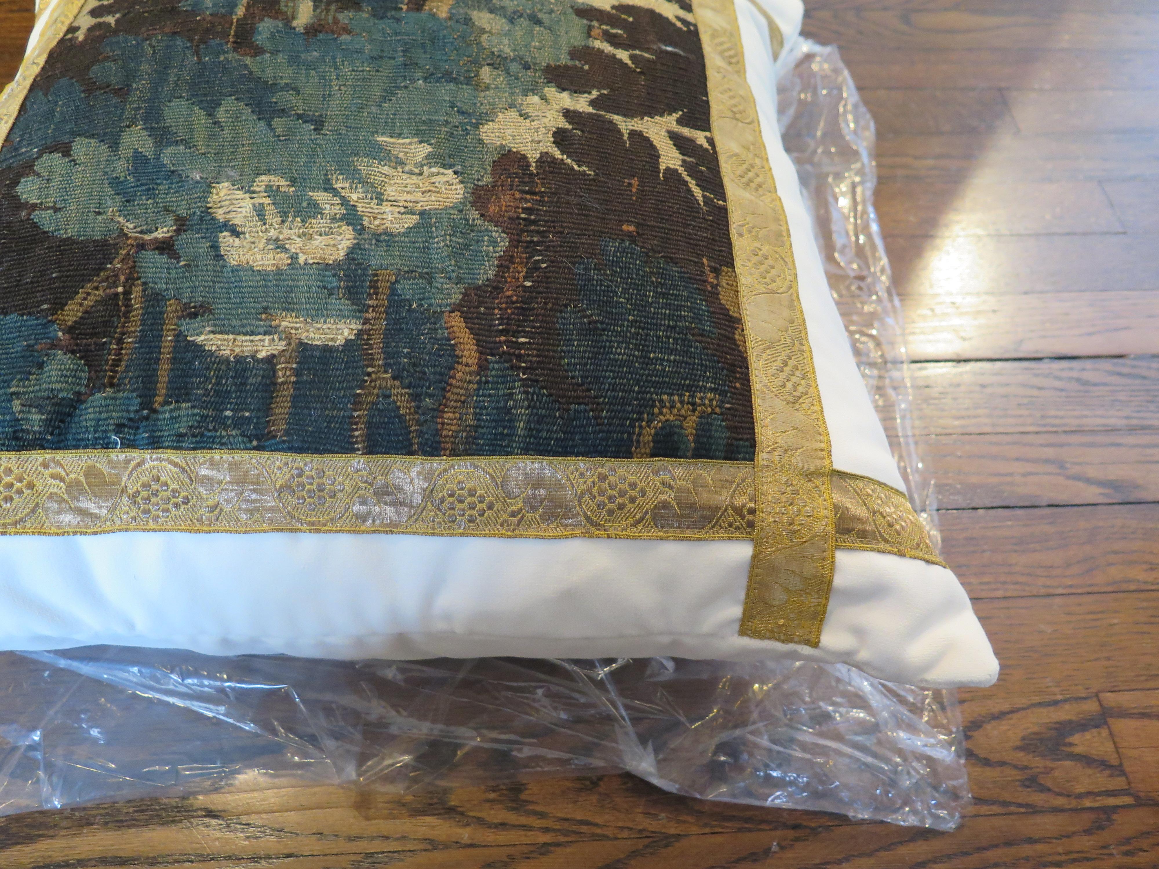 Custom 18th century verdure tapestry pillow adorned with antique French gallon. Pillow is constructed out of Holly Hunt Performance white velvet. Down filled.