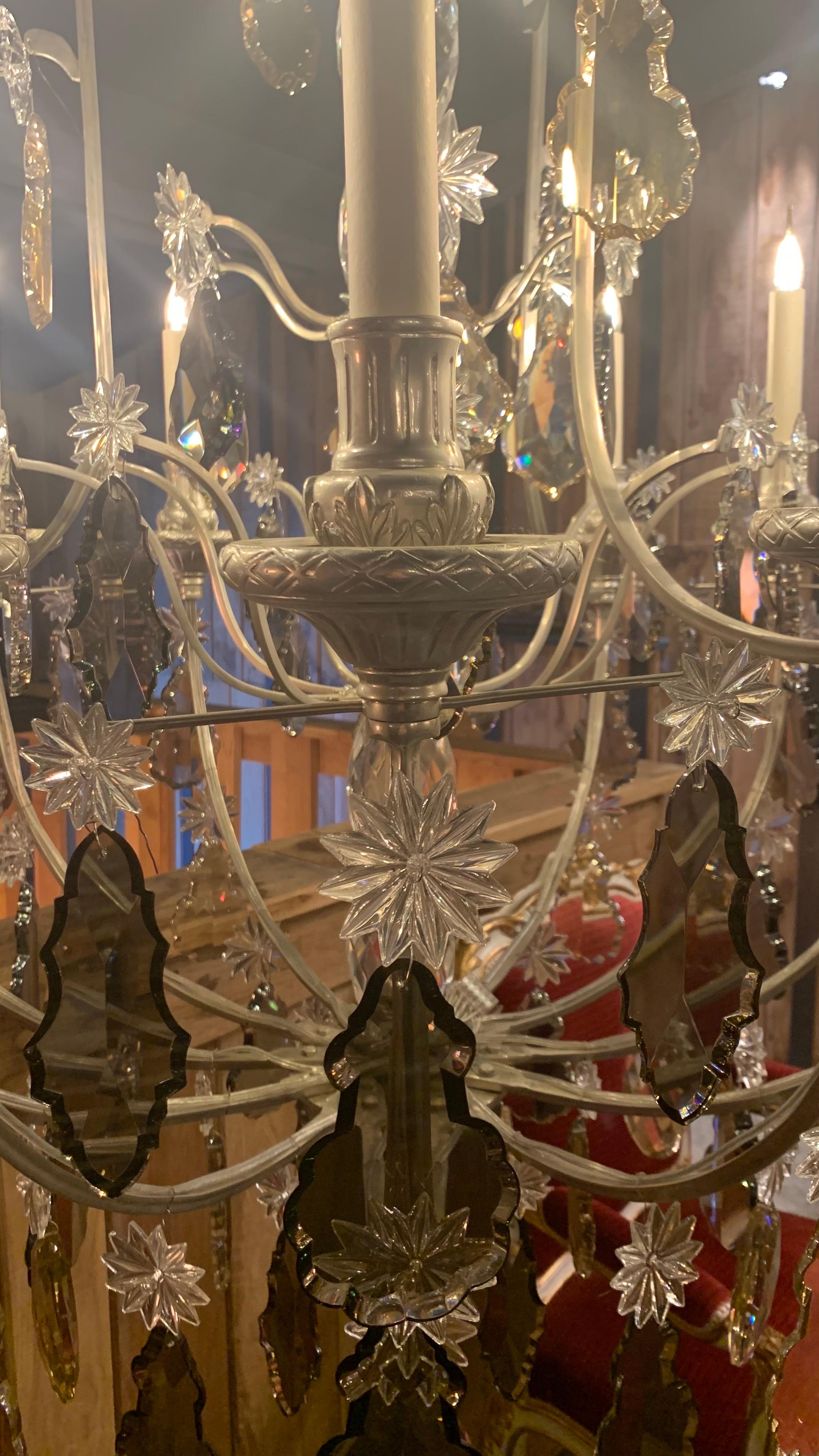 Dieser Kronleuchter ist direkt von den symbolträchtigen Kronleuchtern des Spiegelsaals im Schloss von Versailles inspiriert.

Sie besteht aus einem zentralen, mit Kristallperlen verzierten Schaft, der von einer geigenförmigen Struktur umgeben