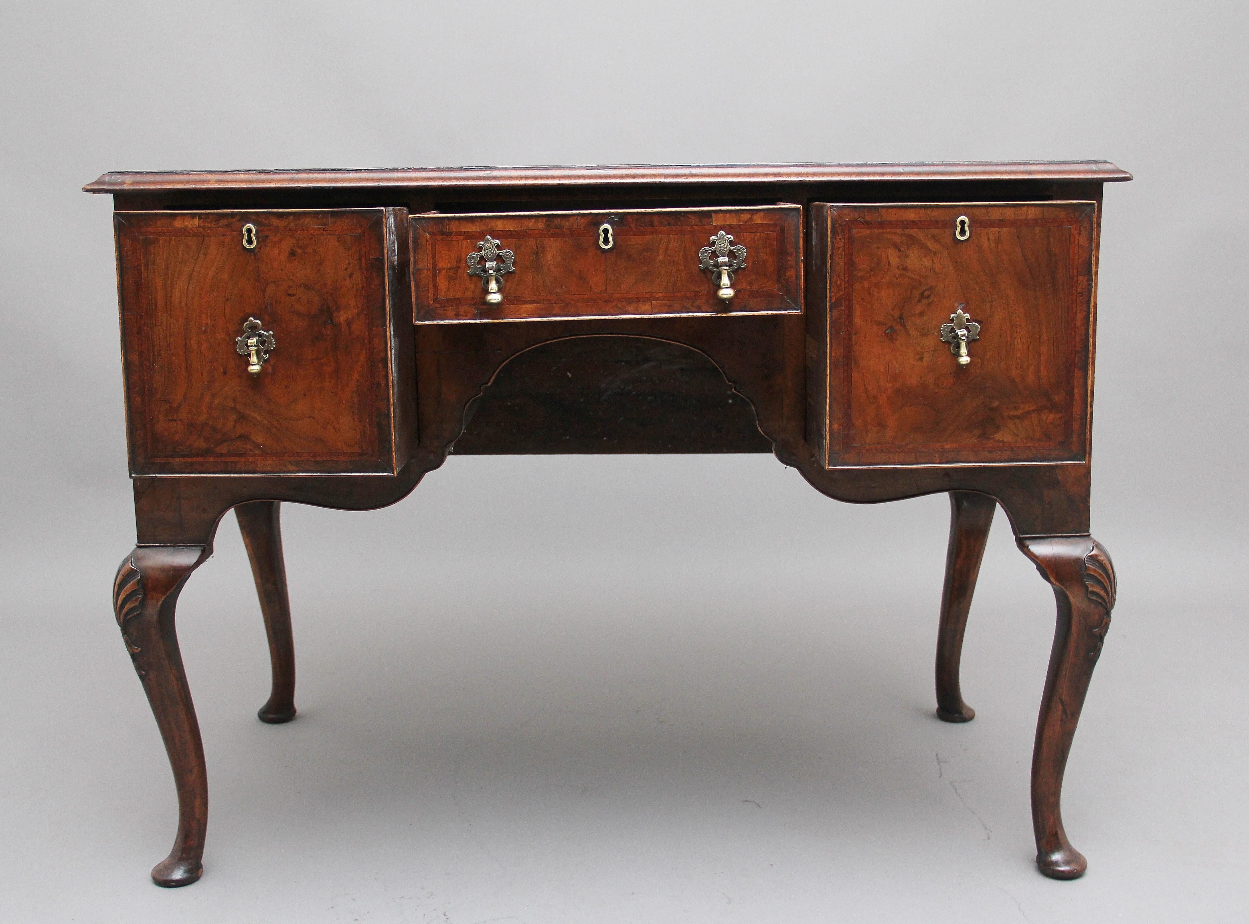18th century walnut and feather banded side table / lowboy, the moulded edge top crossbanded and decorated with feather banding above a selection of three oak lined drawers with original brass handles, the drawer fronts also having feather banding,