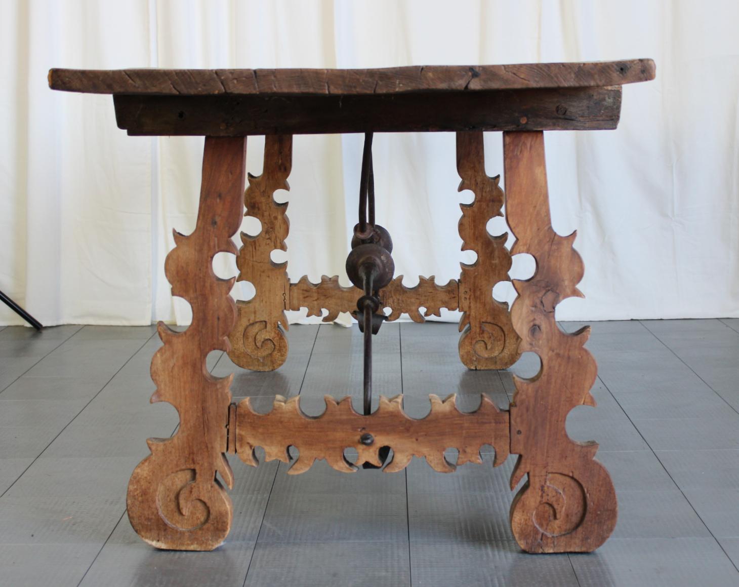 An outstanding 18th century dining table from Spain.
A single slab of walnut top with fantastic aged patina and rough grain.
Hand forged iron stretchers with gorgeous lyre shaped legs.
It is in completely original condition. Not restored.