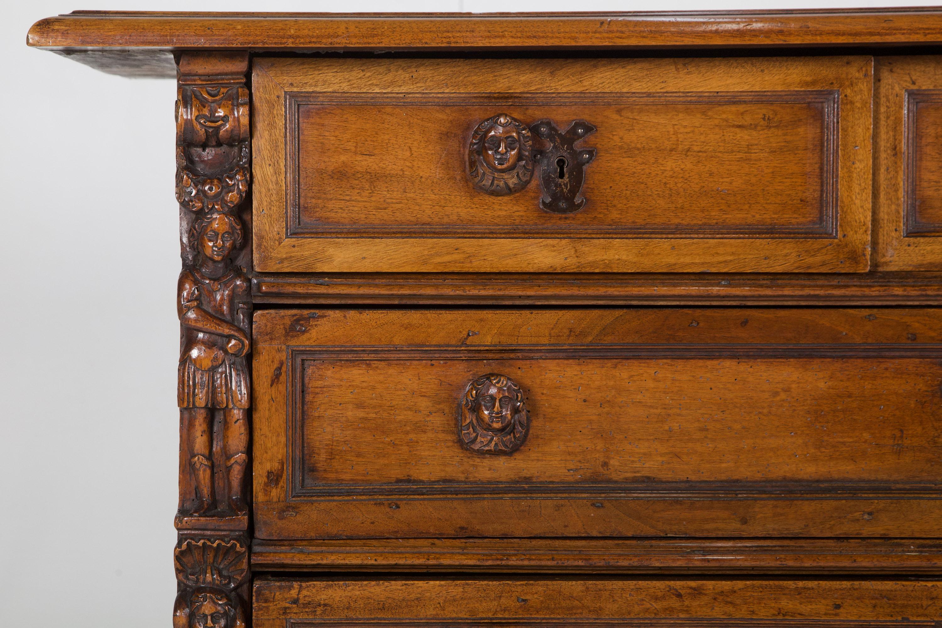 Impressive Walnut Bambocci Commode. Locking Central Small drawer flanked by two further short over three long drawers. Panelled sides with deep moulding. Intricate Bambocci figure head handles and the putti to each side are beautifully carved,