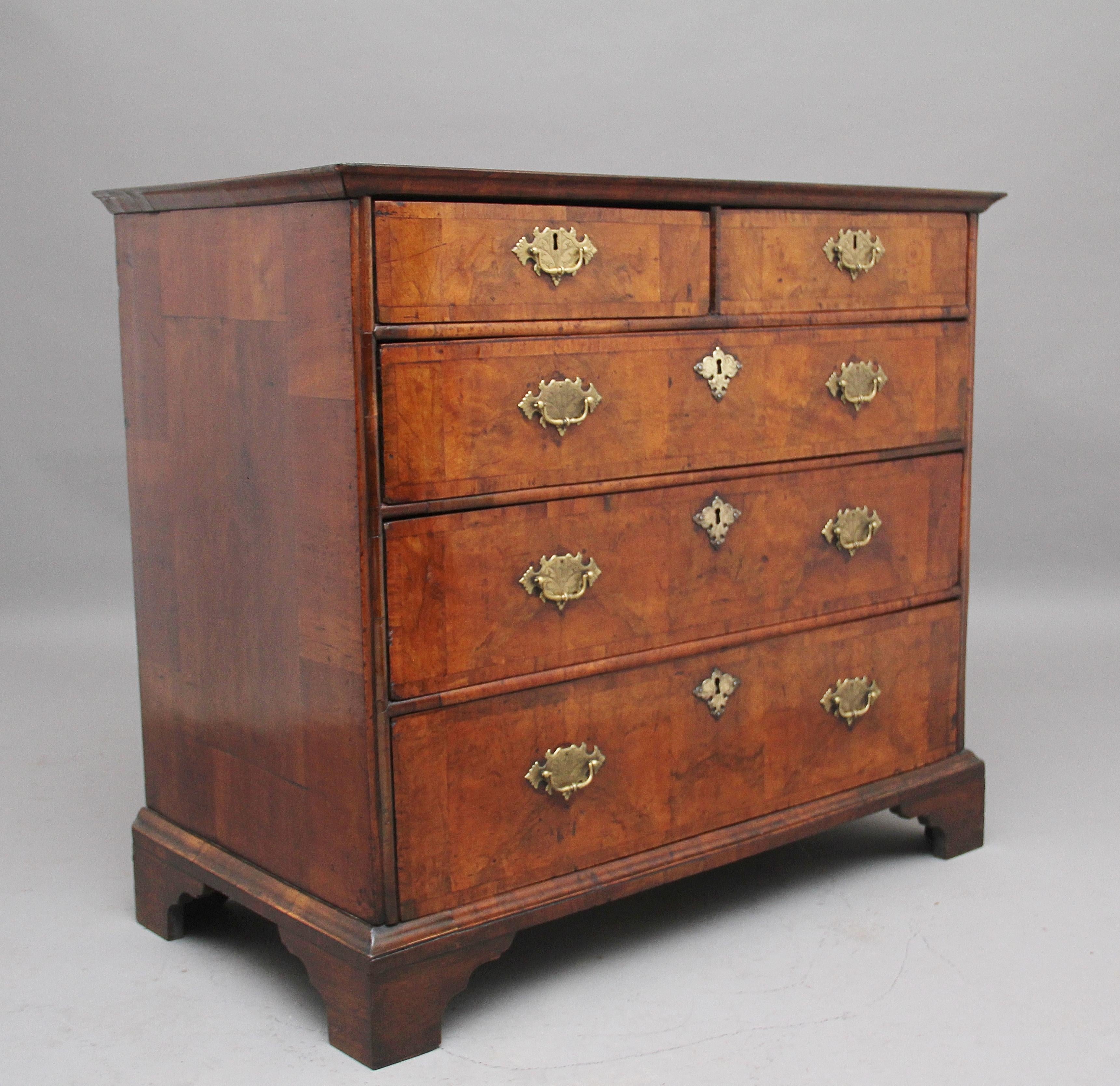 18th century walnut chest of drawers, the quartered and crossbanded rectangular moulded top over two short and three long oak lined graduated drawers with brass plate handles and escutcheons, standing on bracket feet, circa 1770.
  