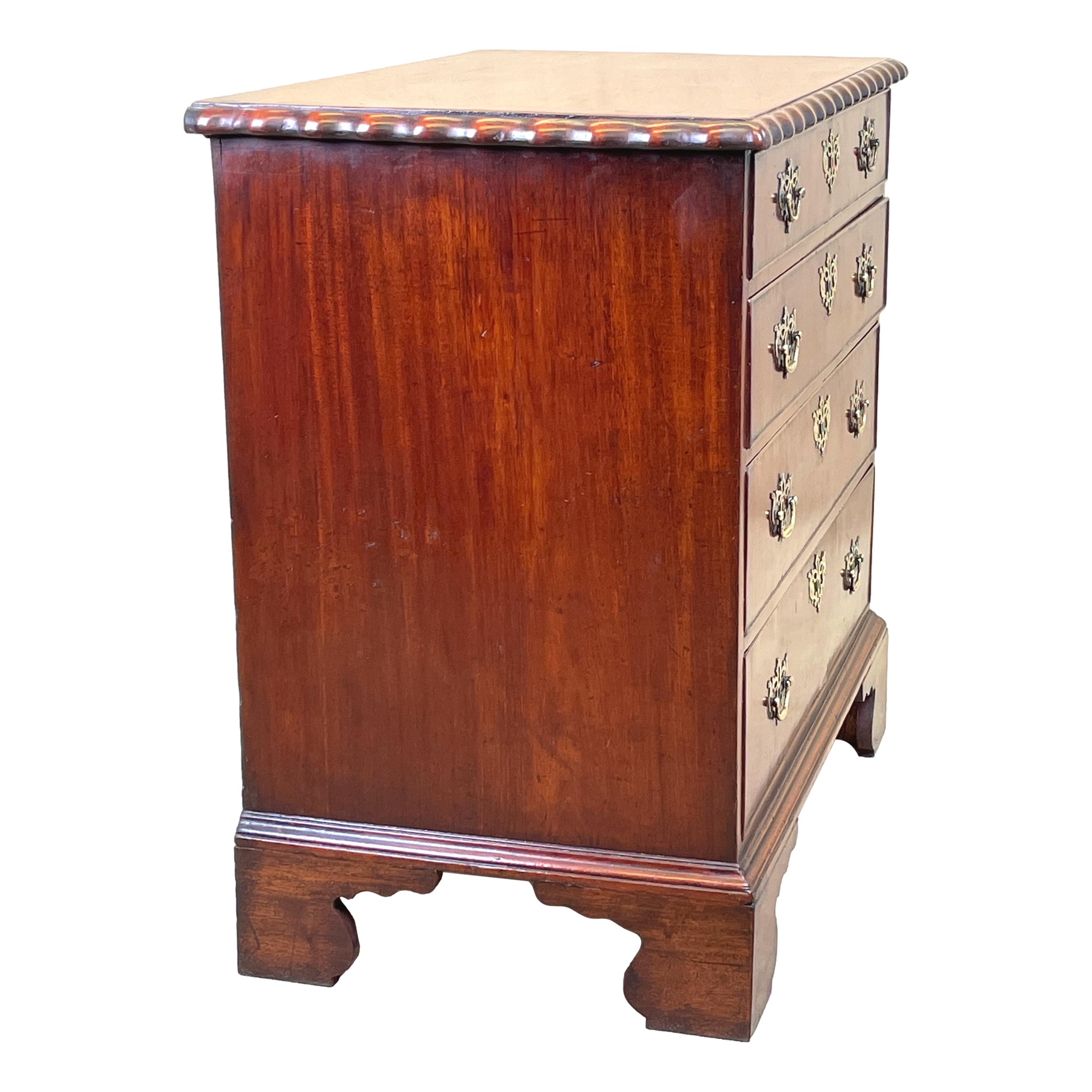 An Attractive and very good quality mid 18th century walnut chest, retaining good colour throughout, with unusual bold wavy moulded edge to top over four long drawers with replacement pierced plate brass handles, raised on elegant shaped bracket