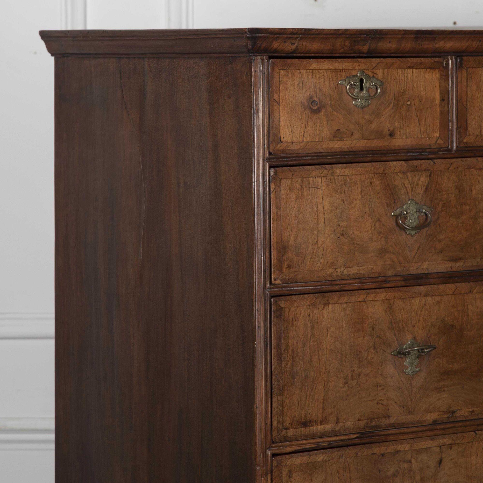 Beautiful 18th Century English walnut chest on stand.
This fine piece is of small proportion and retains its beautiful, slightly faded finish and patination. The oak-lined drawers are decorated with brass drop handles.
The piece has only had one