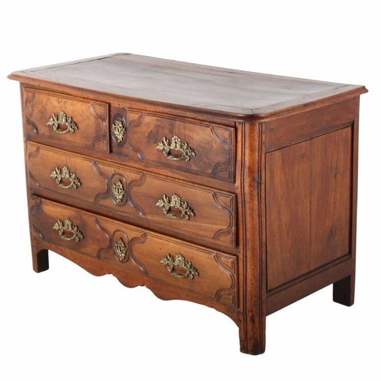 A late 18th Century French walnut commode, with two full drawers and two half drawers. The warm color of the walnut is nicely offset by the lovely brass accents and hand-carvings, circa 1790.

 