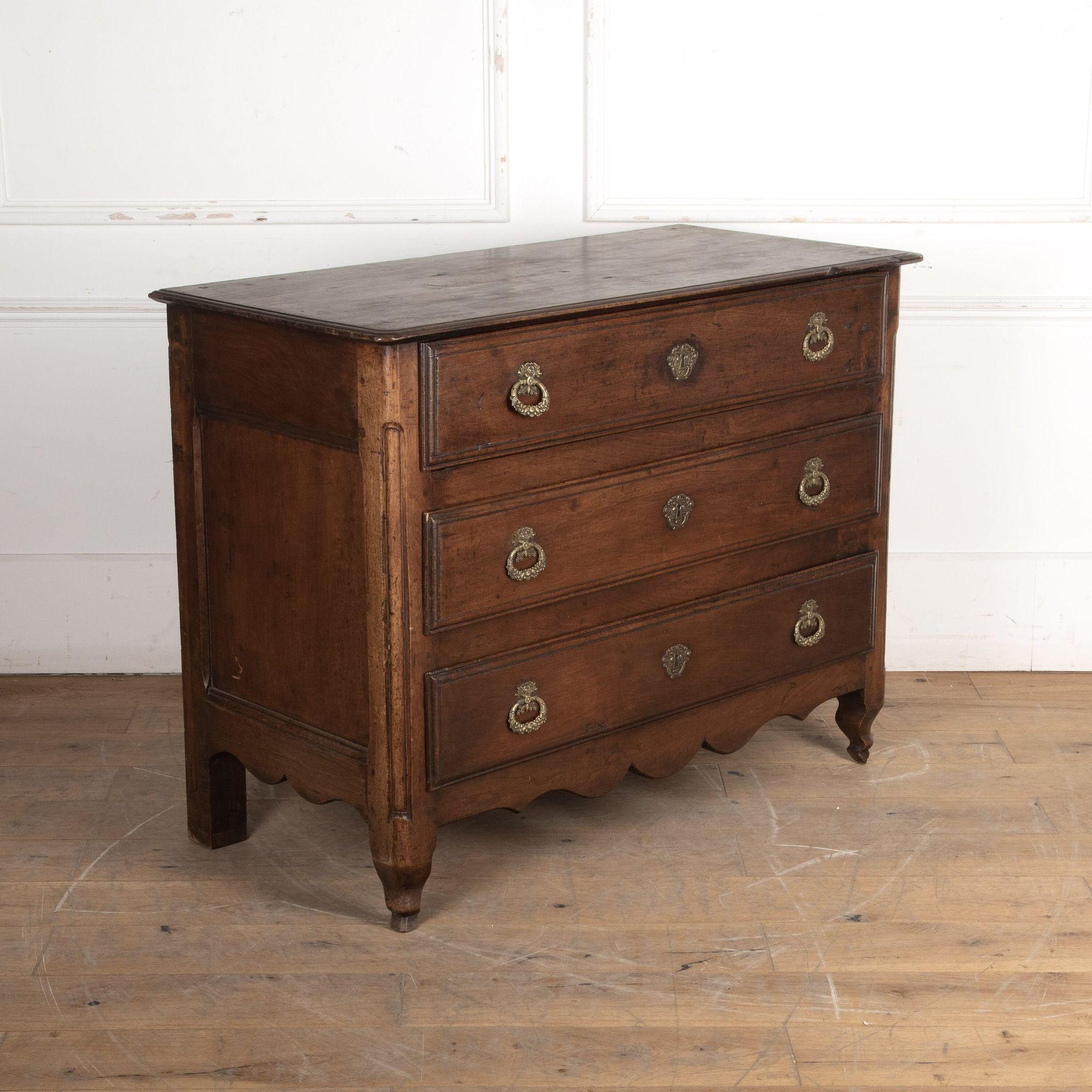 18th century Robust three drawer commode with a deep, warm patina.
Cornucopian themes on the brass drop handles and faux escutcheons. The top has 