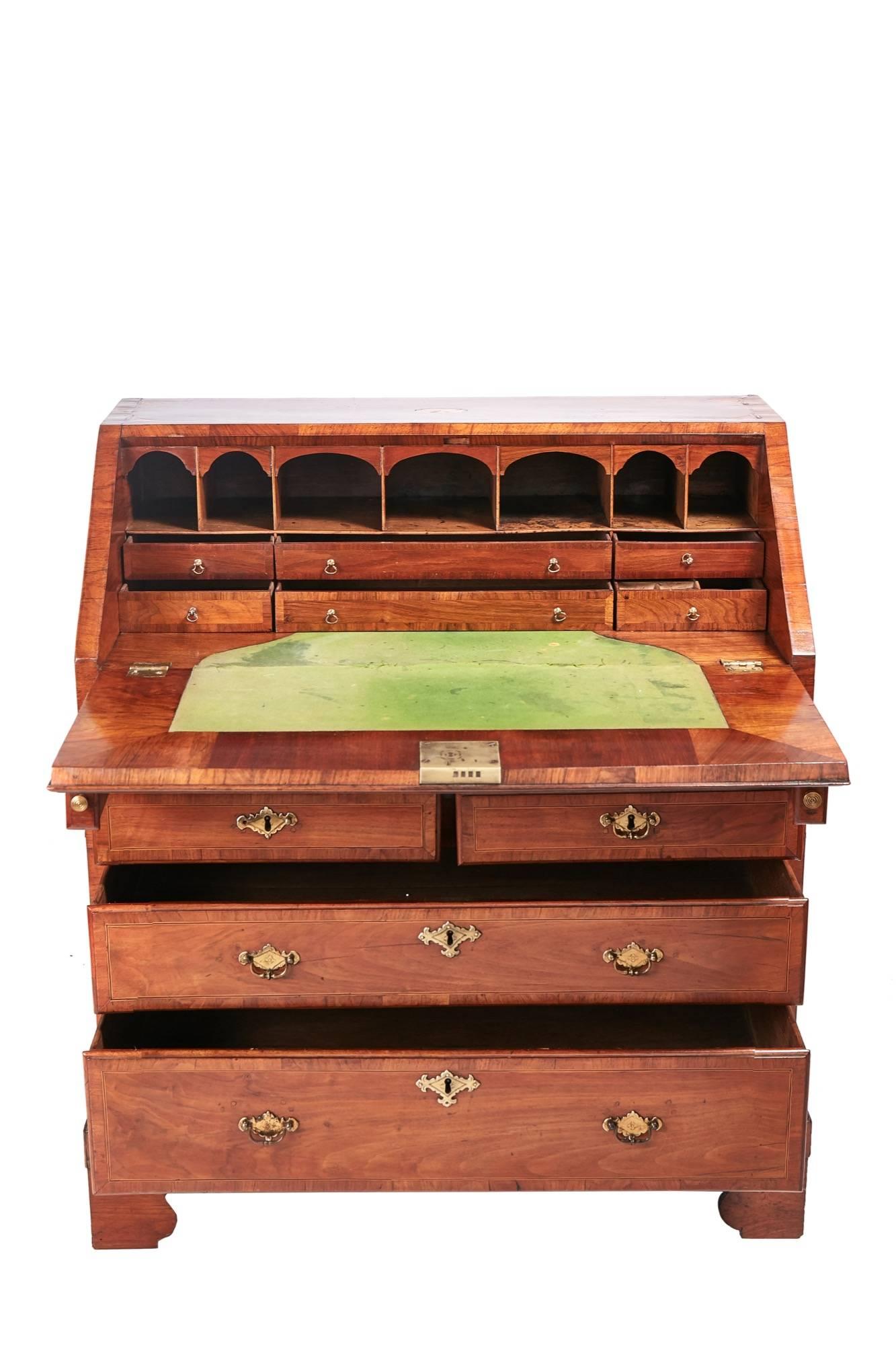 18th century walnut crossbanded and patera inlaid bureau with lovely inlaid sloping fall enclosing a fitted interior of short drawers and pigeonholes and shaped baize writing surface, one narrow drawer over two short and two long drawers all with