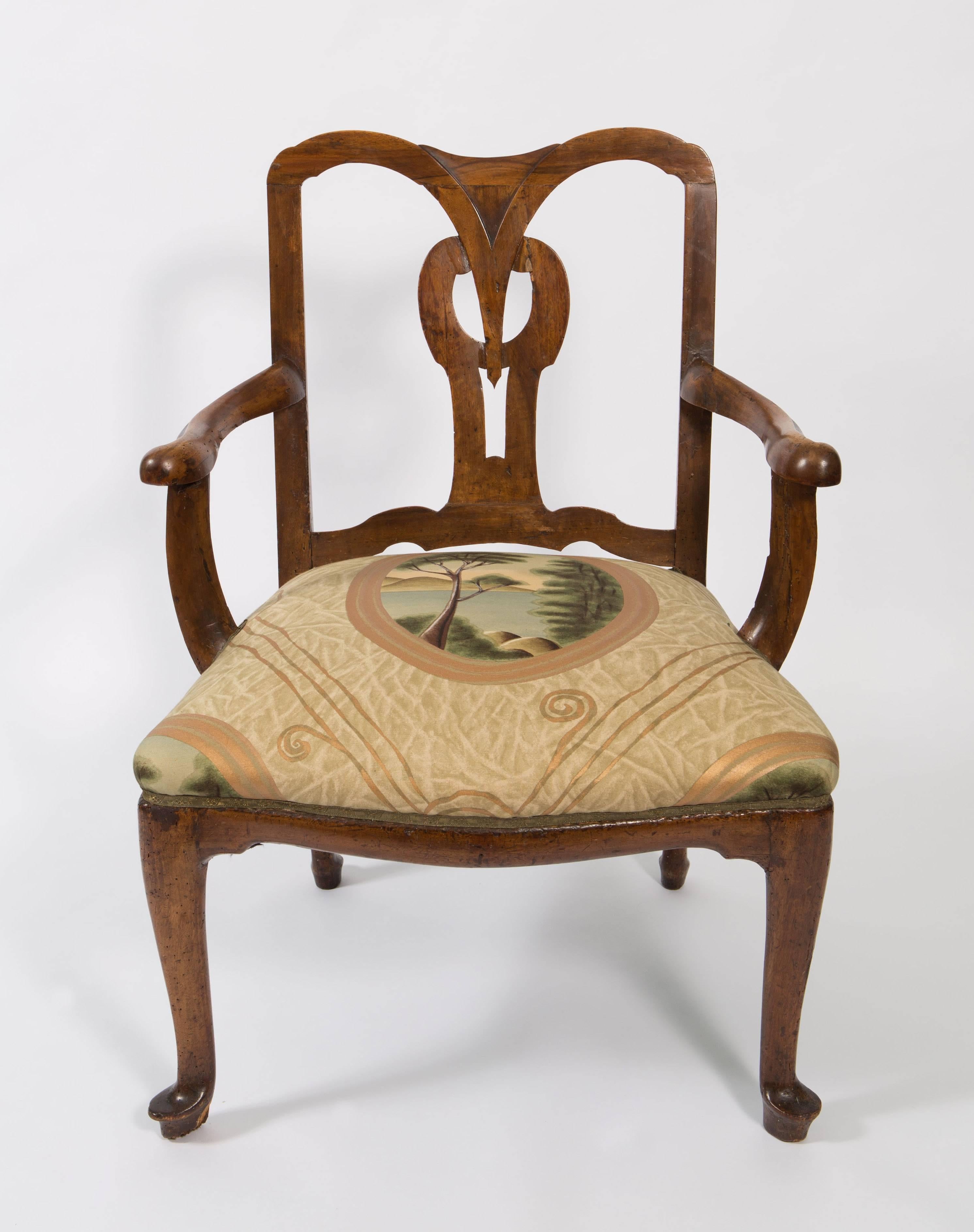 18th century Italian armchair has a beautiful open back with center design back.  It is a walnut chair with open-arms and slate back. The fabric is a new fabric but it is trimmed in antique flat braid. Fabric is in excellent condition.