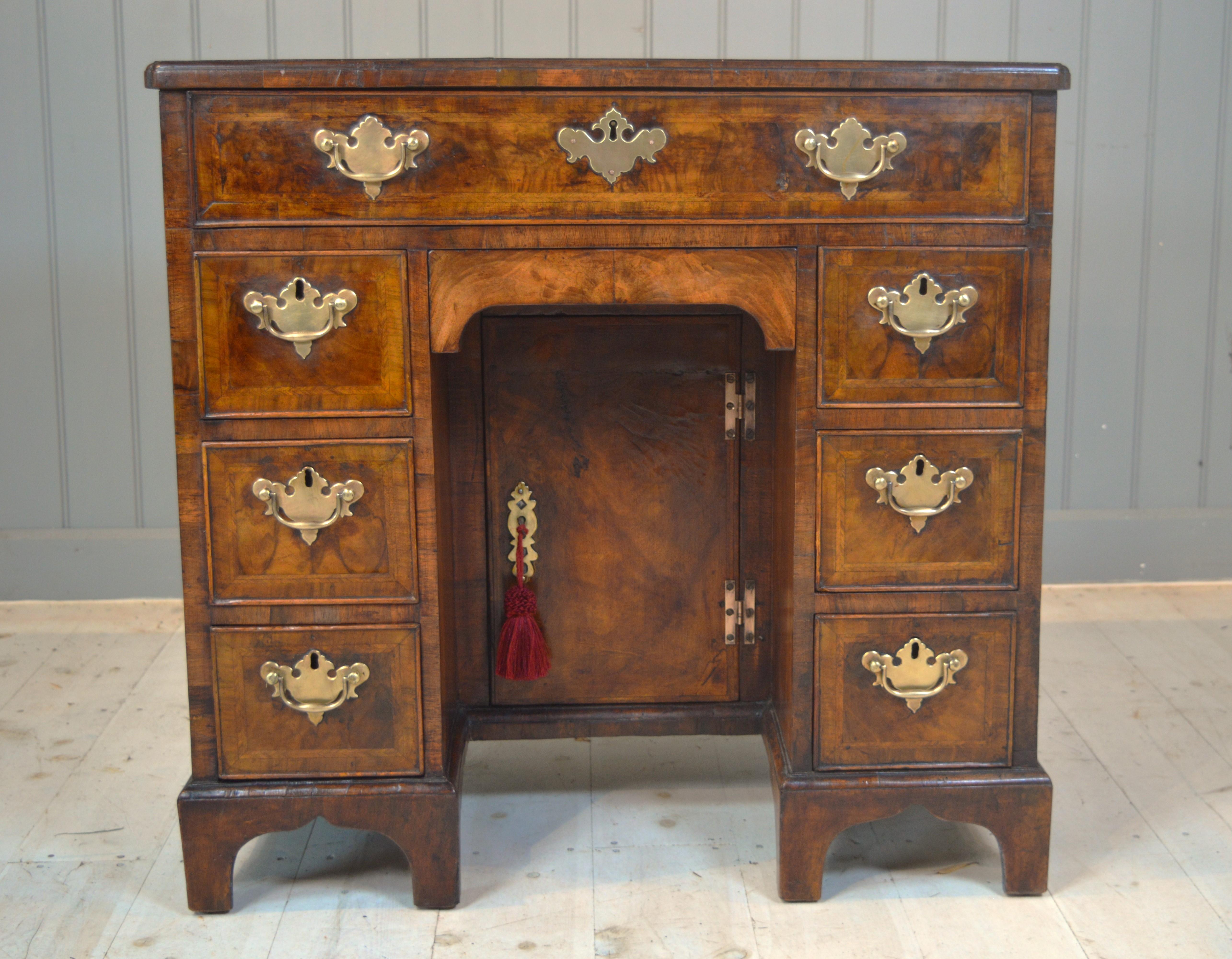 This is a really nice 18th century figured walnut Knee Hole desk .This desk has oak linings, cock beaded drawers and is sitting on bracket feet ,the veneer is well figured  and is a good colour .The top has a two piece mirrored finish veneer and re