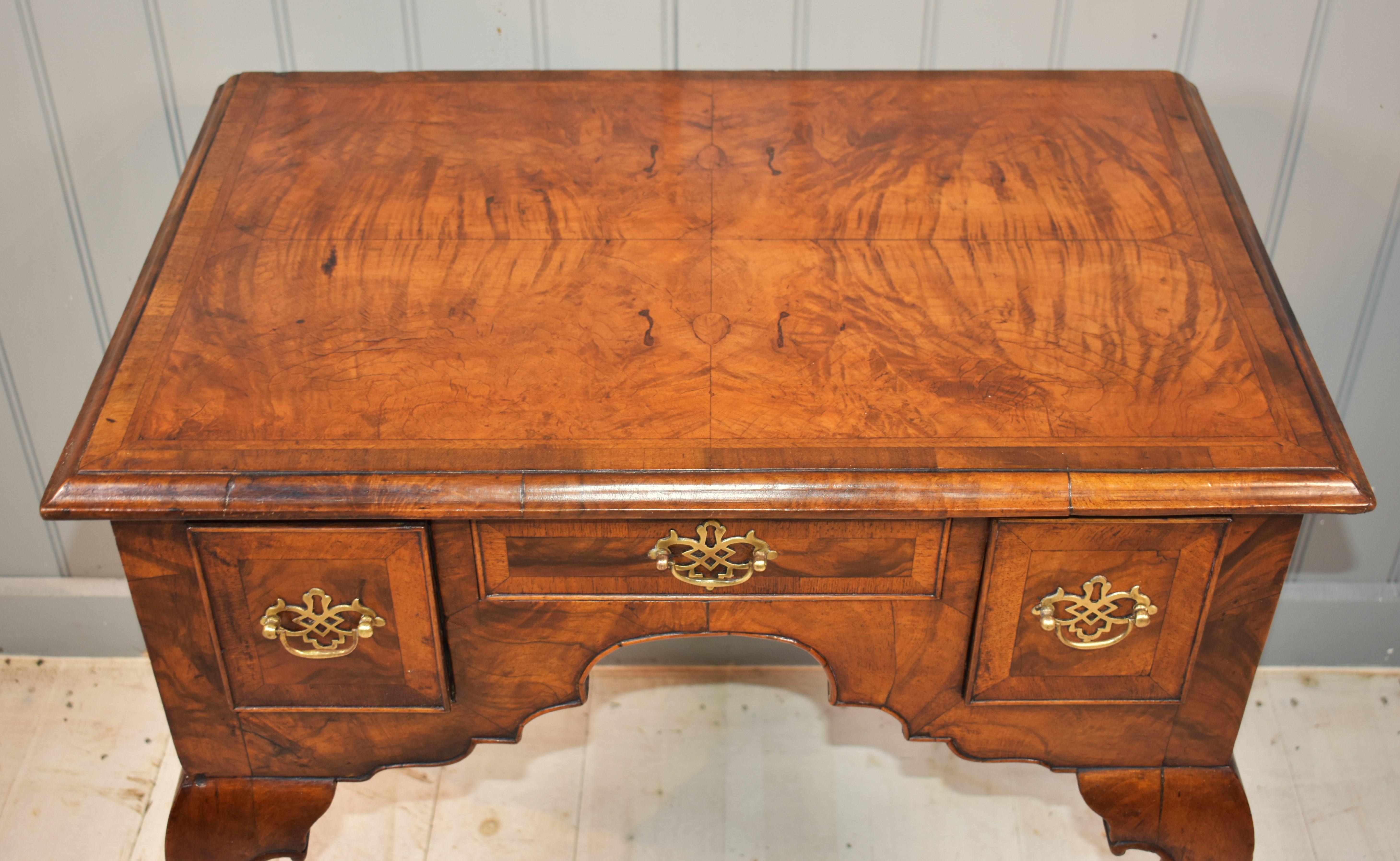 A classic early Georgian lowboy/dressing table c. 1720.  With walnut being particularly fashionable, this piece was made for the elegant town house of the period and exudes quality.  It has a matched quarter veneered top with patterns resembling