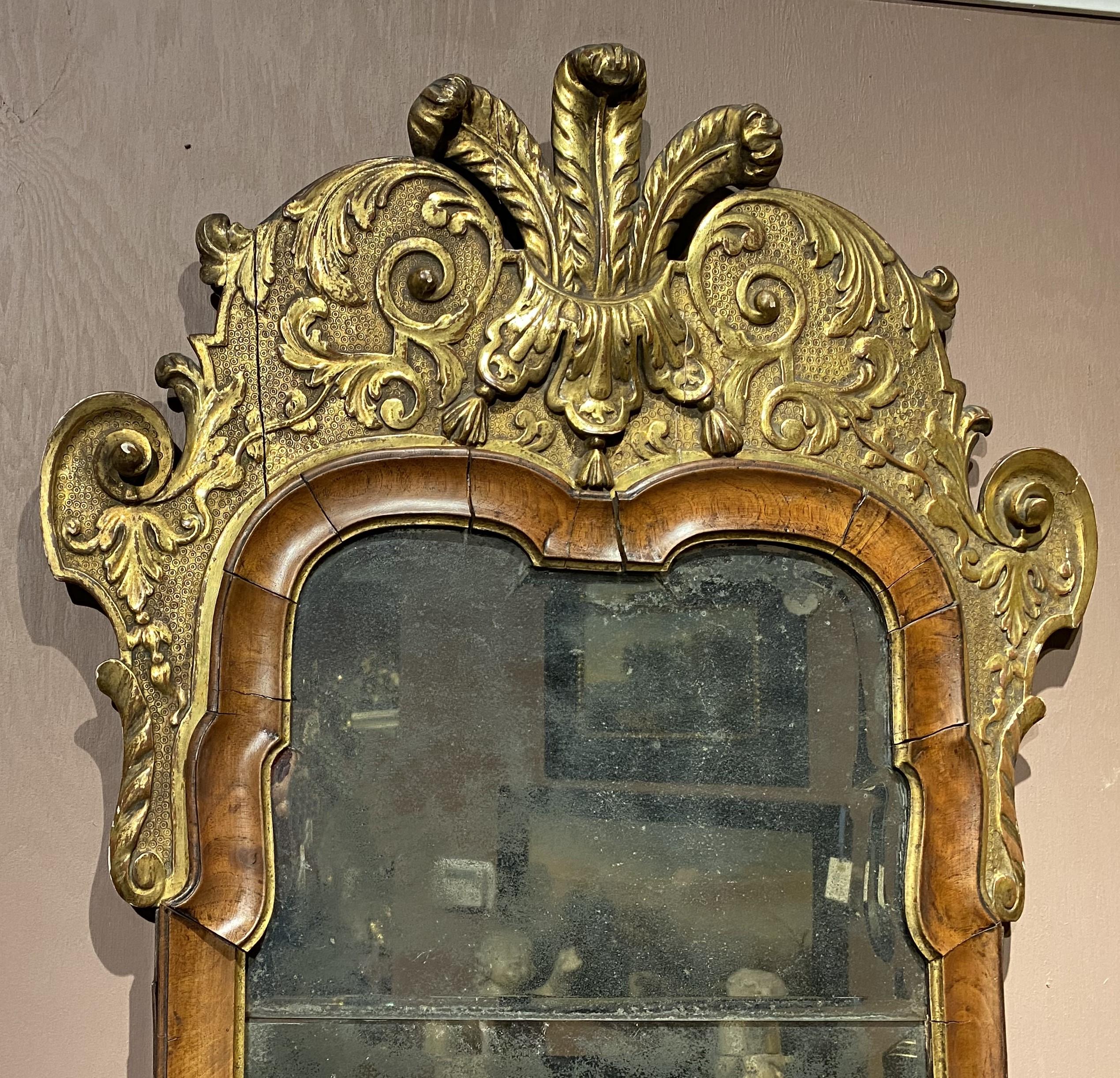 Ein schönes Beispiel für einen englischen Nussbaum- und Mahagoni-Spiegel aus dem 18. Jahrhundert mit originaler Spiegelplatte und vergoldetem, geschnitztem Wappen mit der Feder des Prinzen von Wales. Der Spiegel ist in einem guten Gesamtzustand, mit