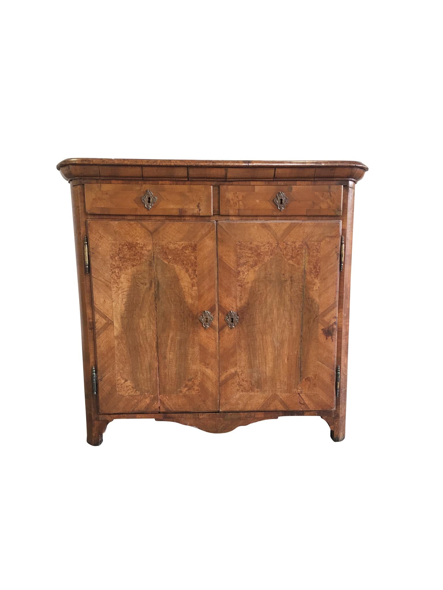 An exquisitely crafted 18th century Italian cabinet. It is comprised of walnut and olive burl wood that are expertly arranged into parquetry. The structural design of the cabinet is Neoclassical, elegant simplicity elaborated with beautiful