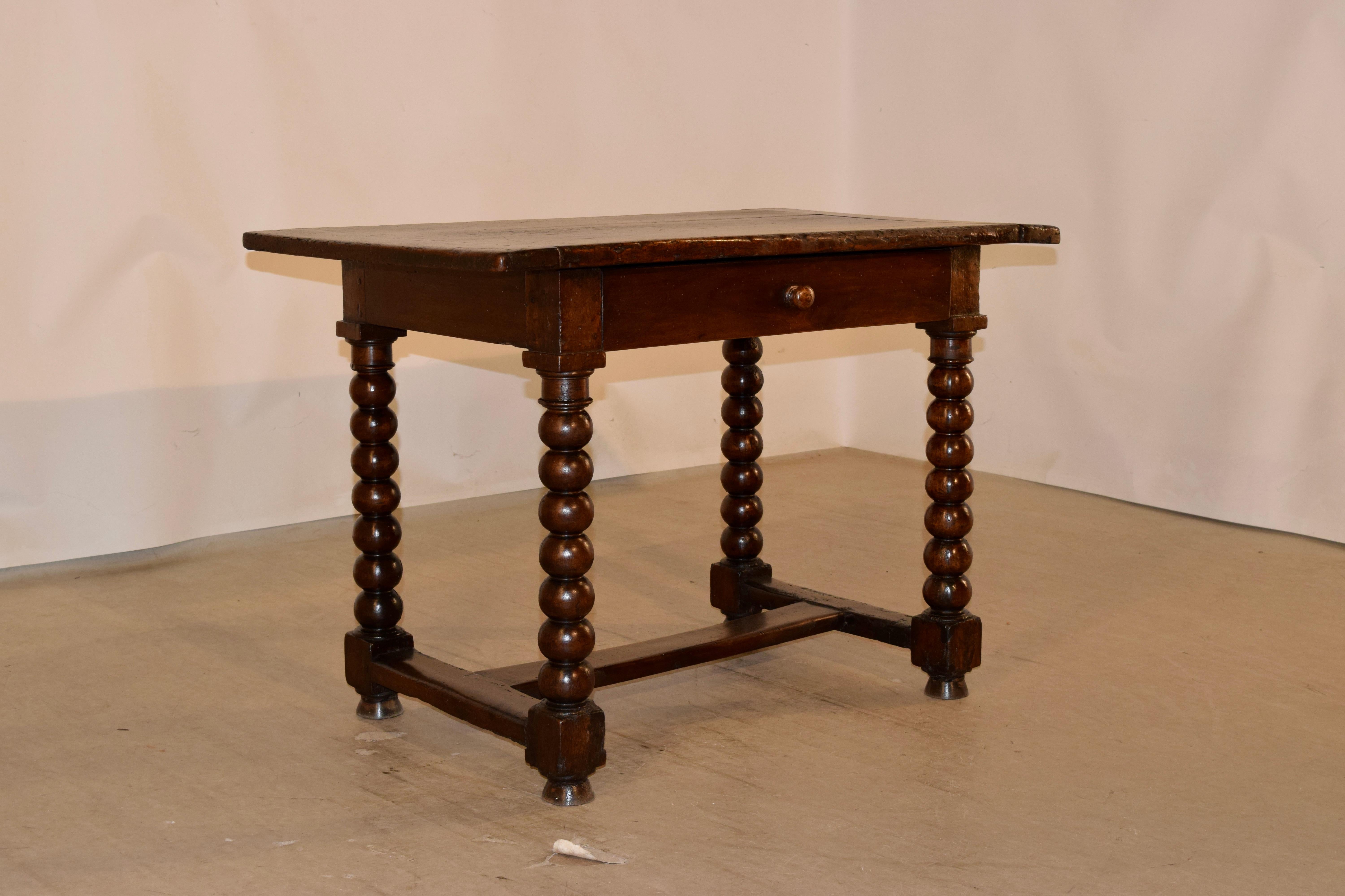 Mid-18th century walnut side table from France, with a banded top and simple apron, containing a single drawer in the front. The legs are heavily hand turned bobbin style and are joined by wonderfully worn stretchers and supported on turned feet.