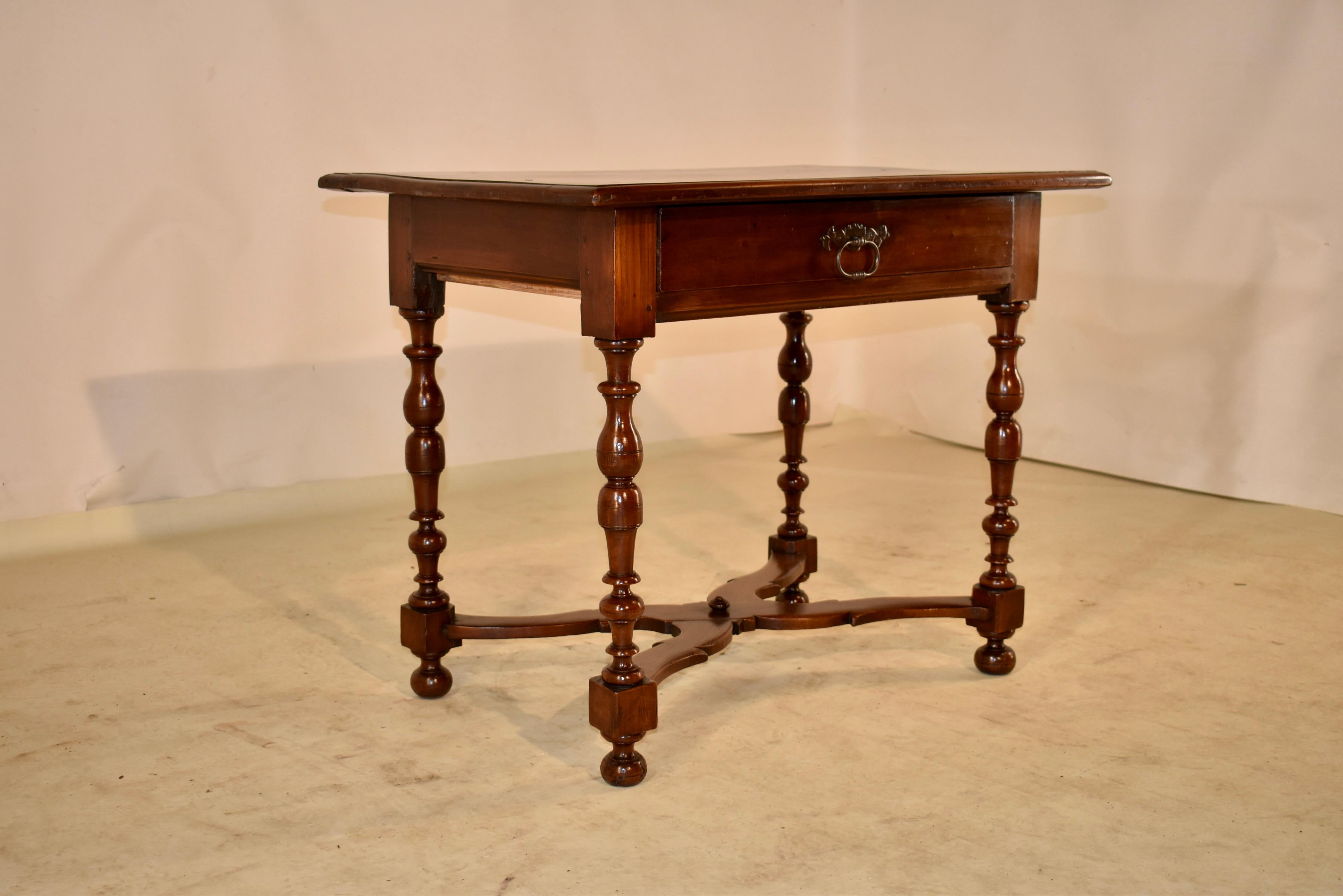 Early 18th century walnut side table from France with a two board top which has pegged construction and a beveled edge, following down to simple sides and a single drawer in the front. The table is supported on hand turned legs, joined by serpentine