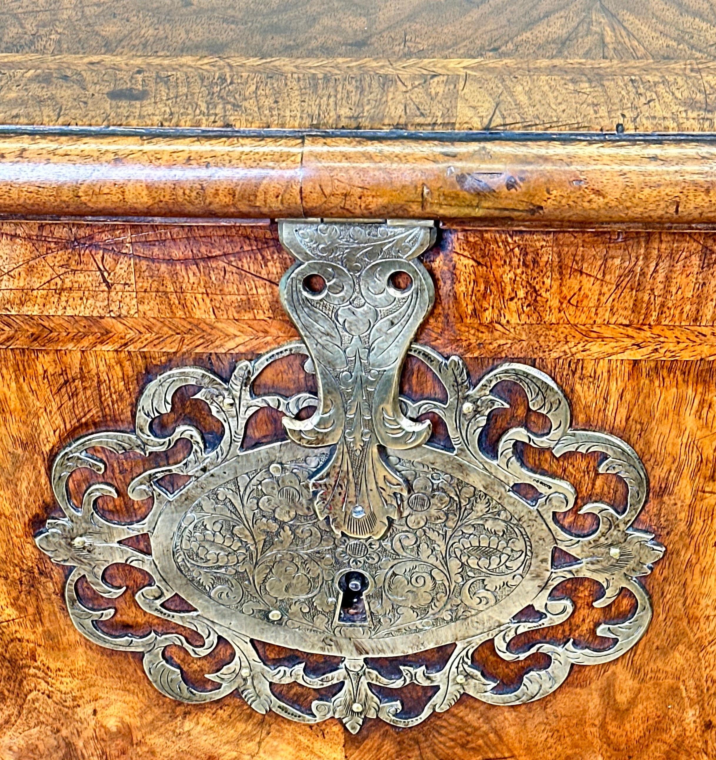 A Charming And Rare Early 18th Century Walnut Silver Chest, Having Superbly Figured Hinged Lid With Attractive Herringbone & Crossbanded Decoration Enclosing Storage, Boasting Fabulous Original Brass Lock Escutcheon And Plate, With Brass Carrying