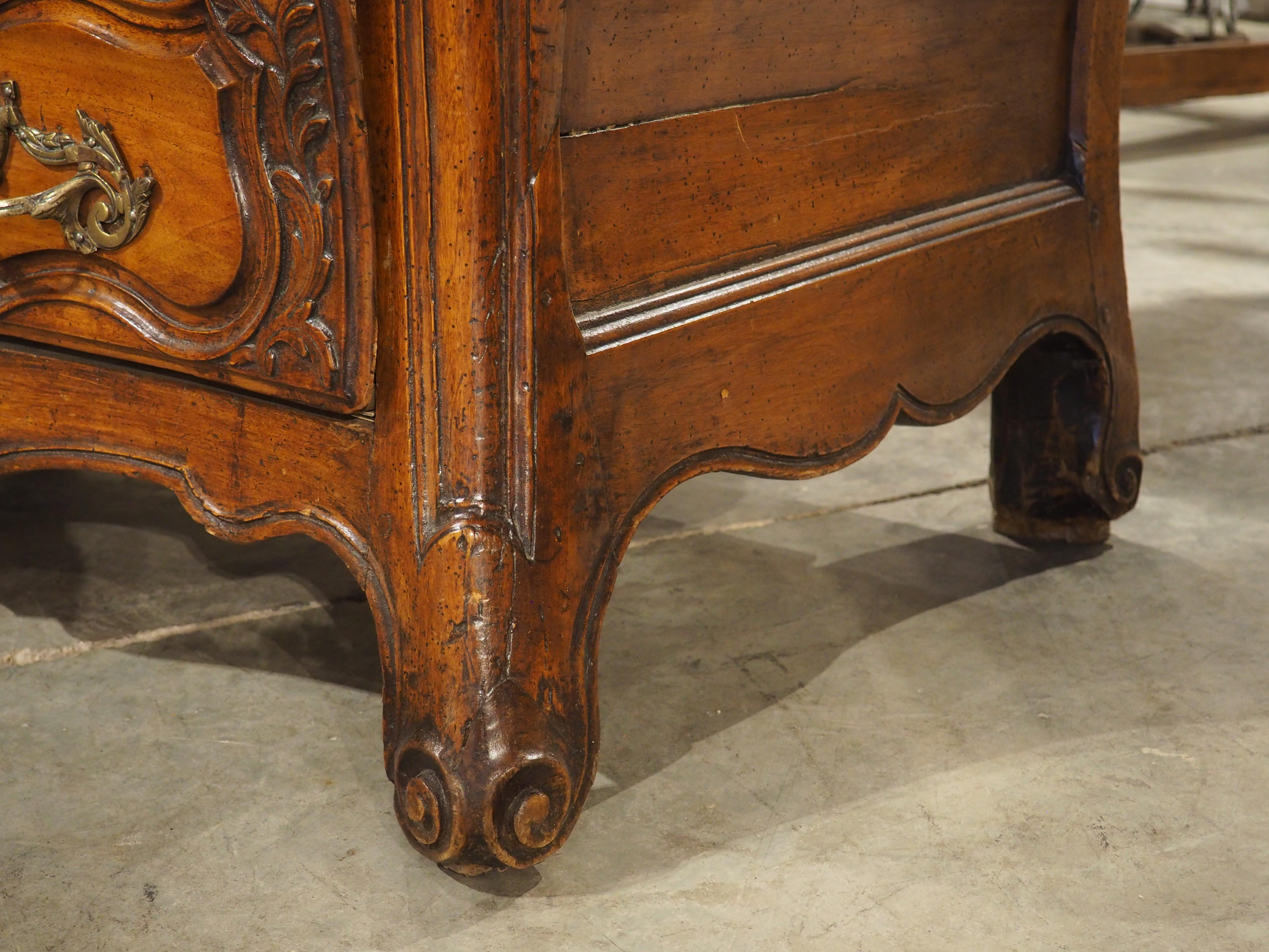 Tallada a mano en madera de nogal durante el siglo XVIII, esta encantadora cómoda procede de Burdeos, Francia. La parte superior tiene una sutil curva arbalete con moldura de cuarto de vuelta, mientras que los laterales tienen una forma saliente más