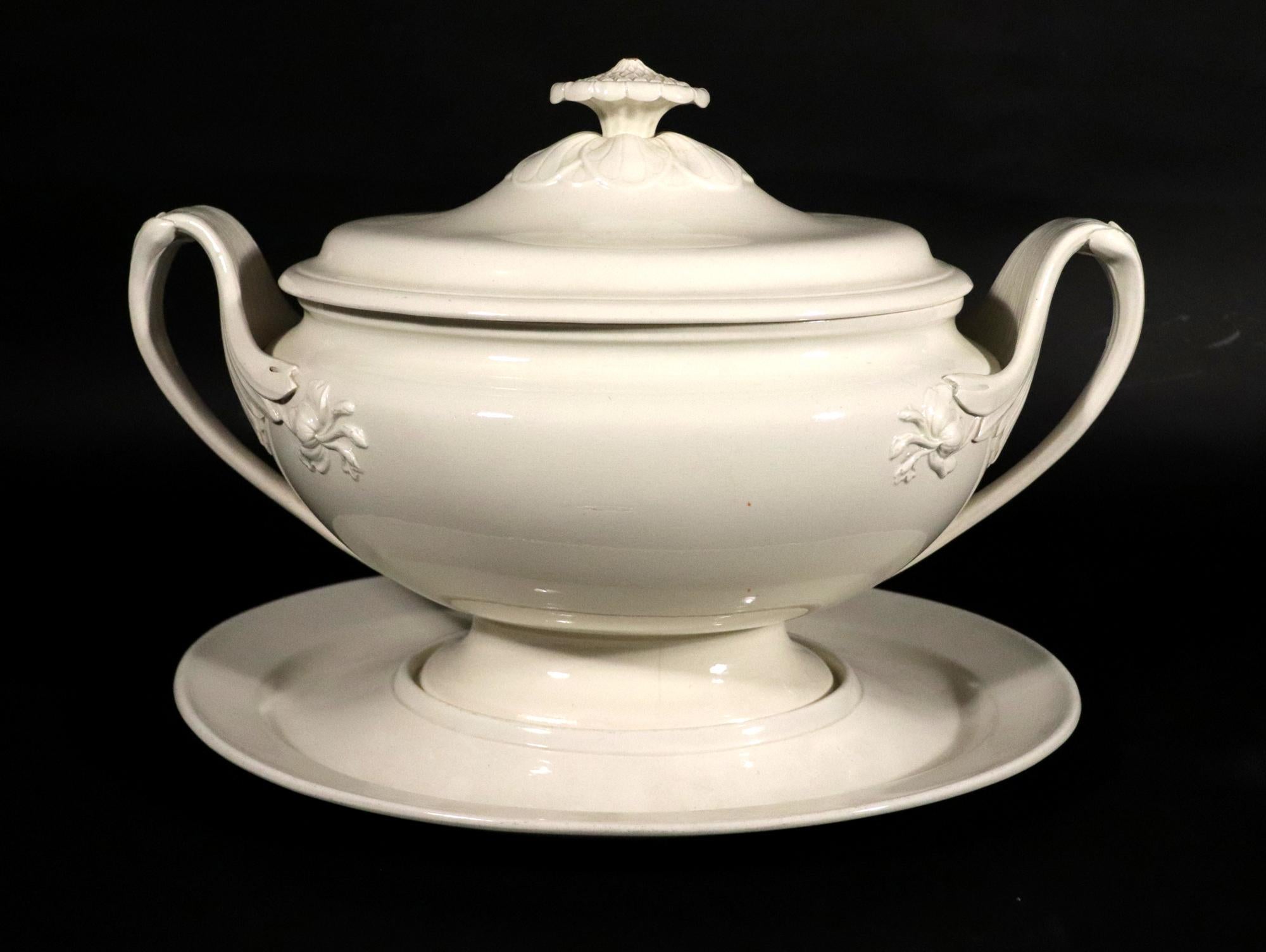 English Creamware Tureen, Cover & Stand,
Wedgwood,
Circa 1790-1800

The Wedgwood creamware soup tureen, cover and stand is of an oval form with dramatic handles with large molded leaf terminals with a molded flower head on the side of the tureen to