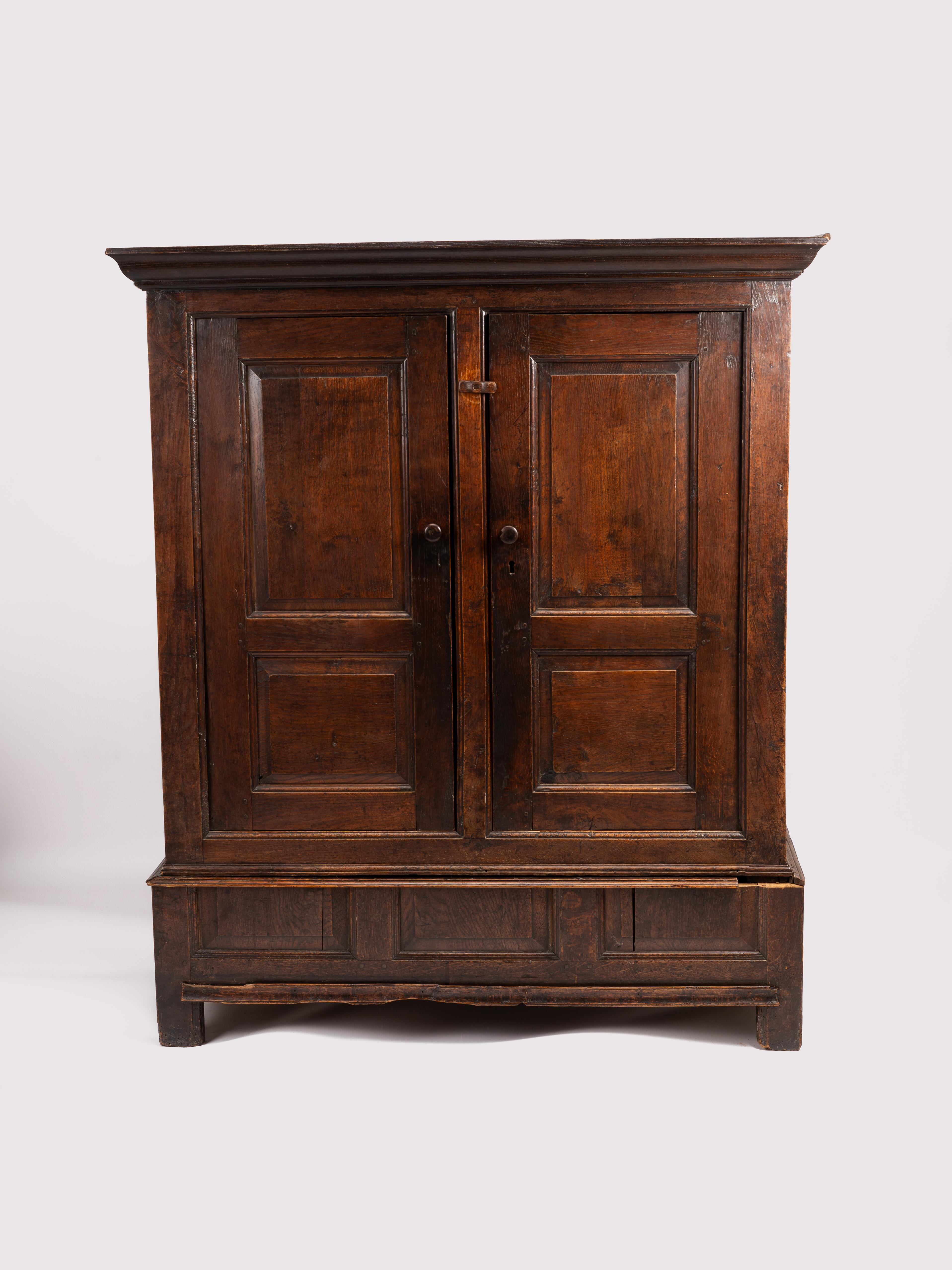 This is a beautiful antique Welsh livery cupboard that was made sometime in the 18th century or late 17th century. The cupboard or cabinet is crafted of old growth oak and features a rich brown patina, with a deep gloss built only over generations