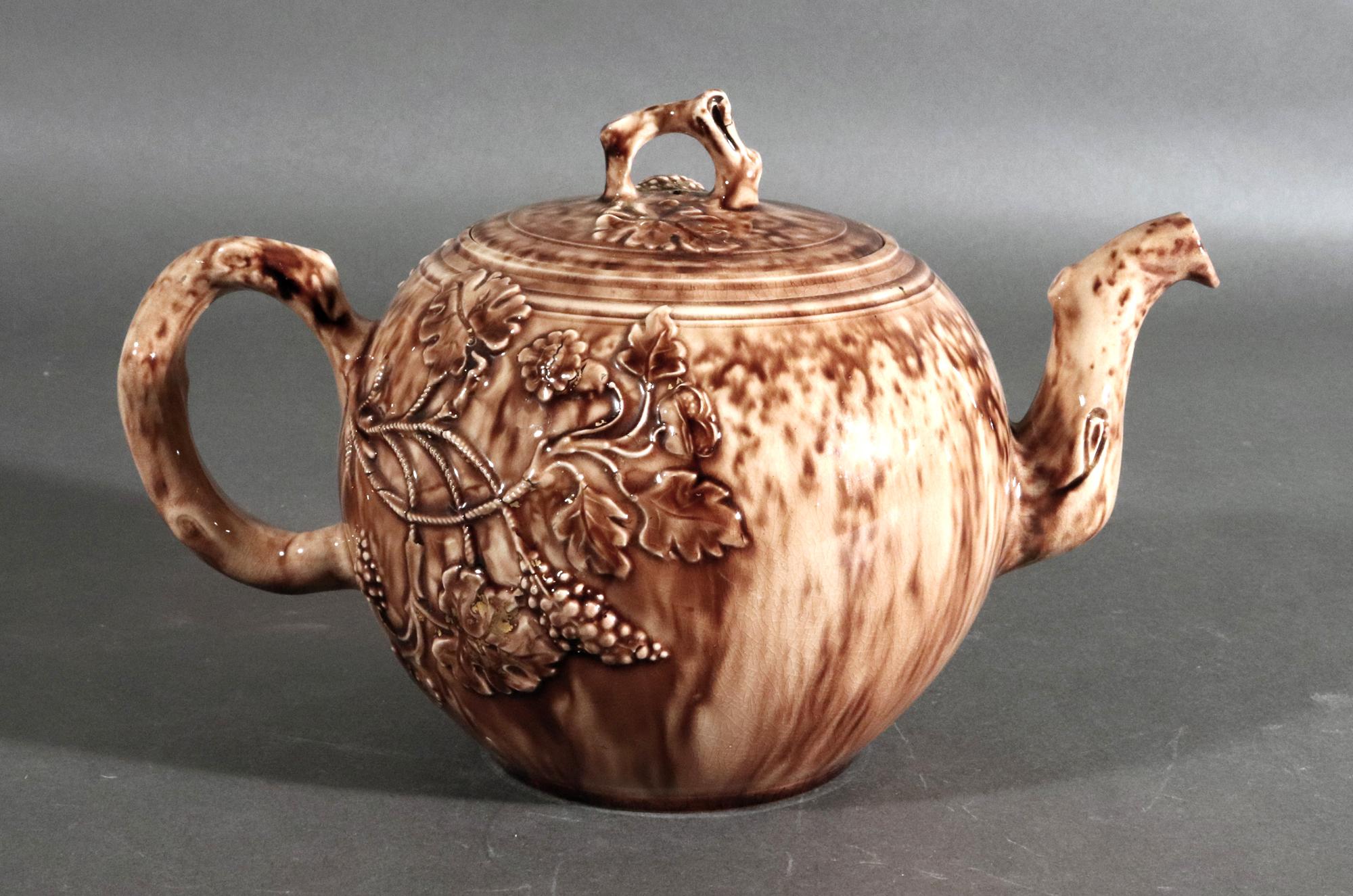 Whieldon-Typ Schildpatt-Teekanne und Deckel aus dem 18. Jahrhundert,
CIRCA 1765

Die aus Schildpatt geformte Teekanne und der Deckel sind mit einem geformten Muster aus Trauben und Blättern verziert, die von der Spitze des Henkels ausgehen, wobei