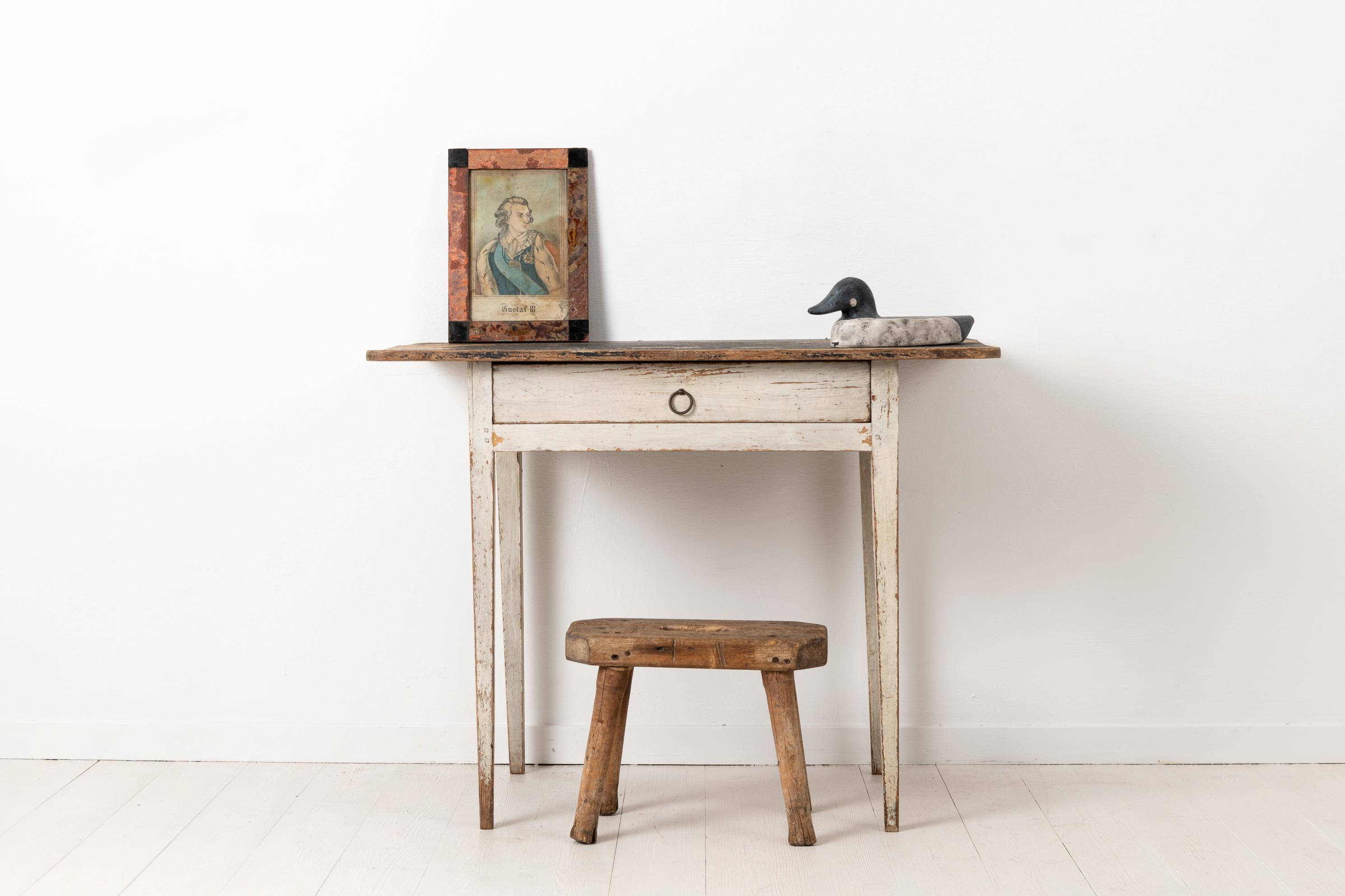Swedish Gustavian desk with white distressed paint. The table is from the late 18th century, circa 1790-1800. Made in pine with distressed white and black paint as well as a genuine patina after almost 250 years of use. Made in the northern part of