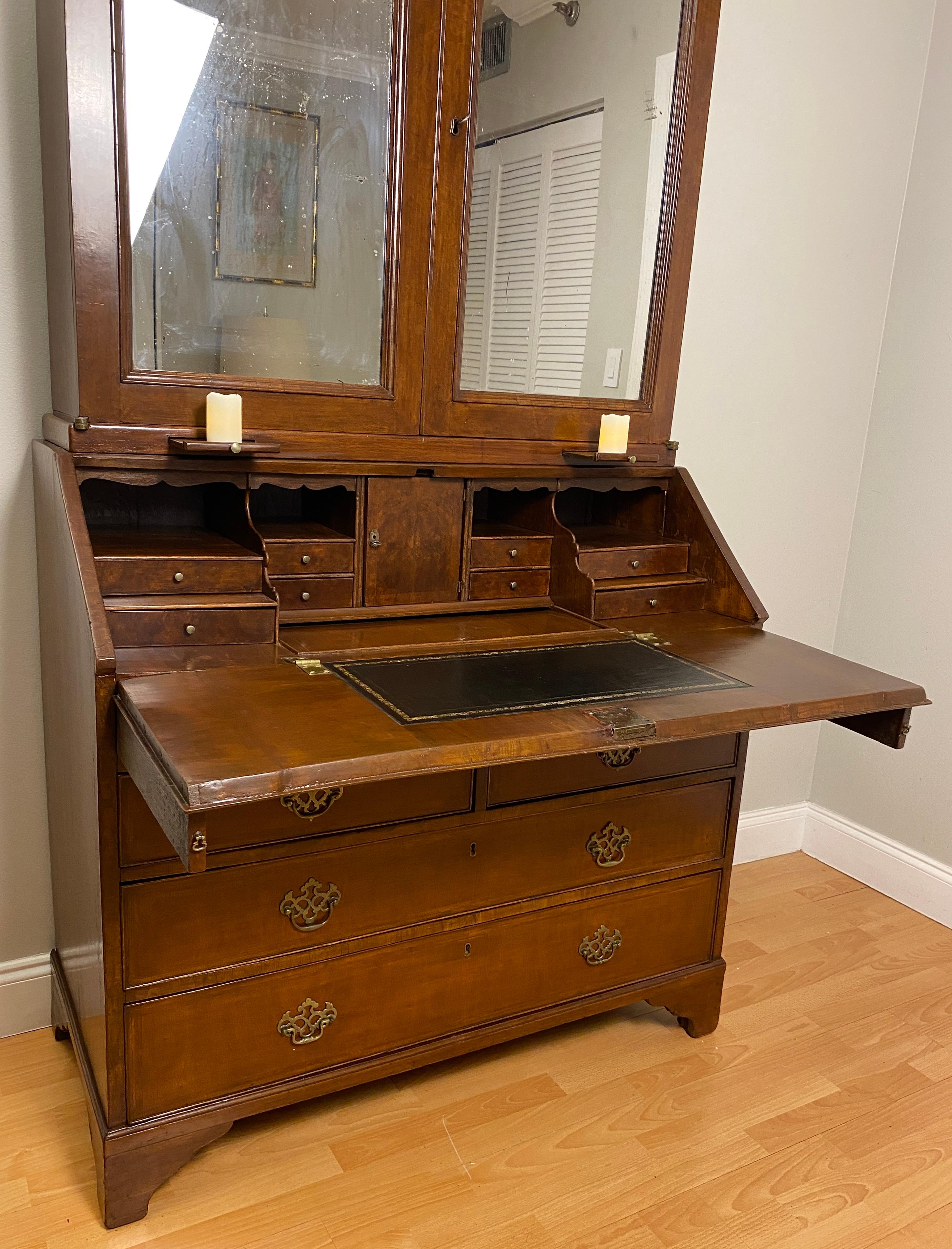 A very fine quality William and Mary style double dome bureau bookcase or antique English walnut cabinet.  This bureau bookcase has an outstanding quality double dome shaped top with a moulded cornice above a pair of doors opening to reveal a