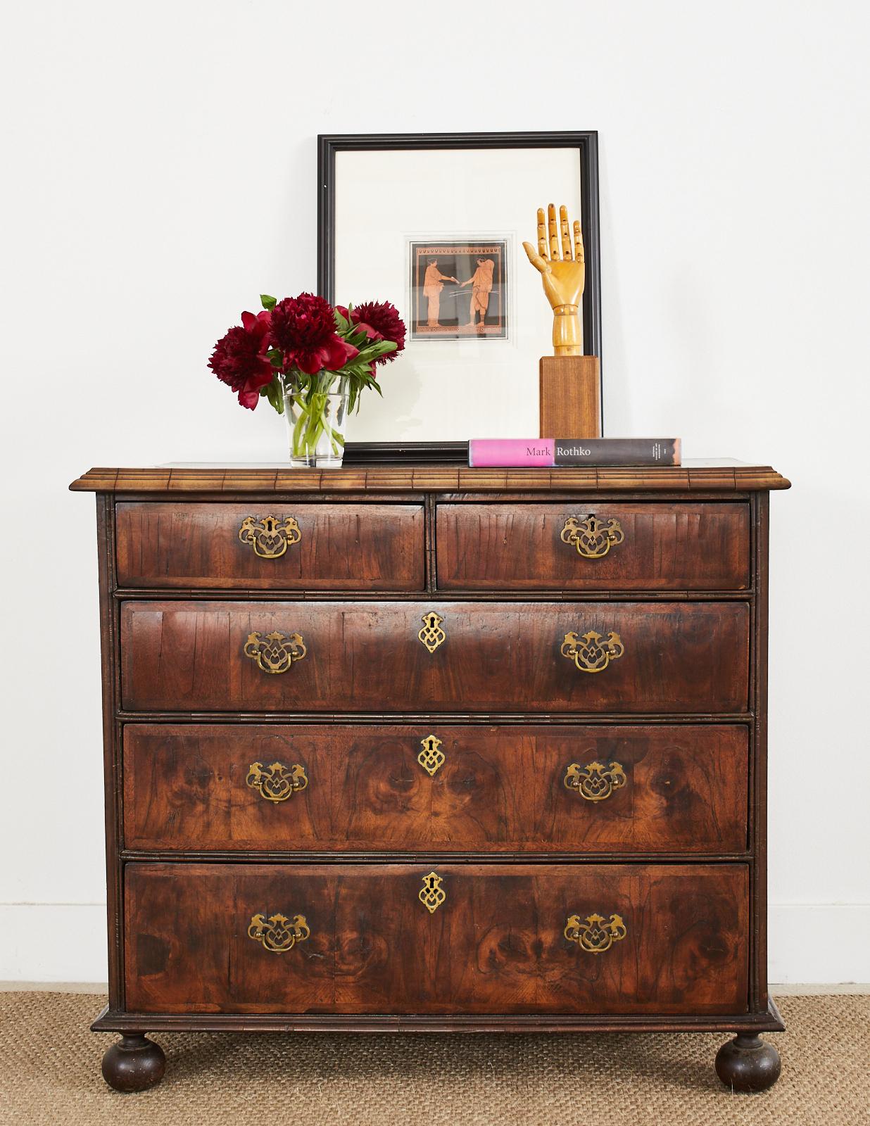 Gorgeous late 17th century/early 18th century walnut veneered William and Mary style commode or chest of drawers. The case features beautifully veneered drawers and top showcasing the rich walnut woodgrains. Mostly original with solid joinery and