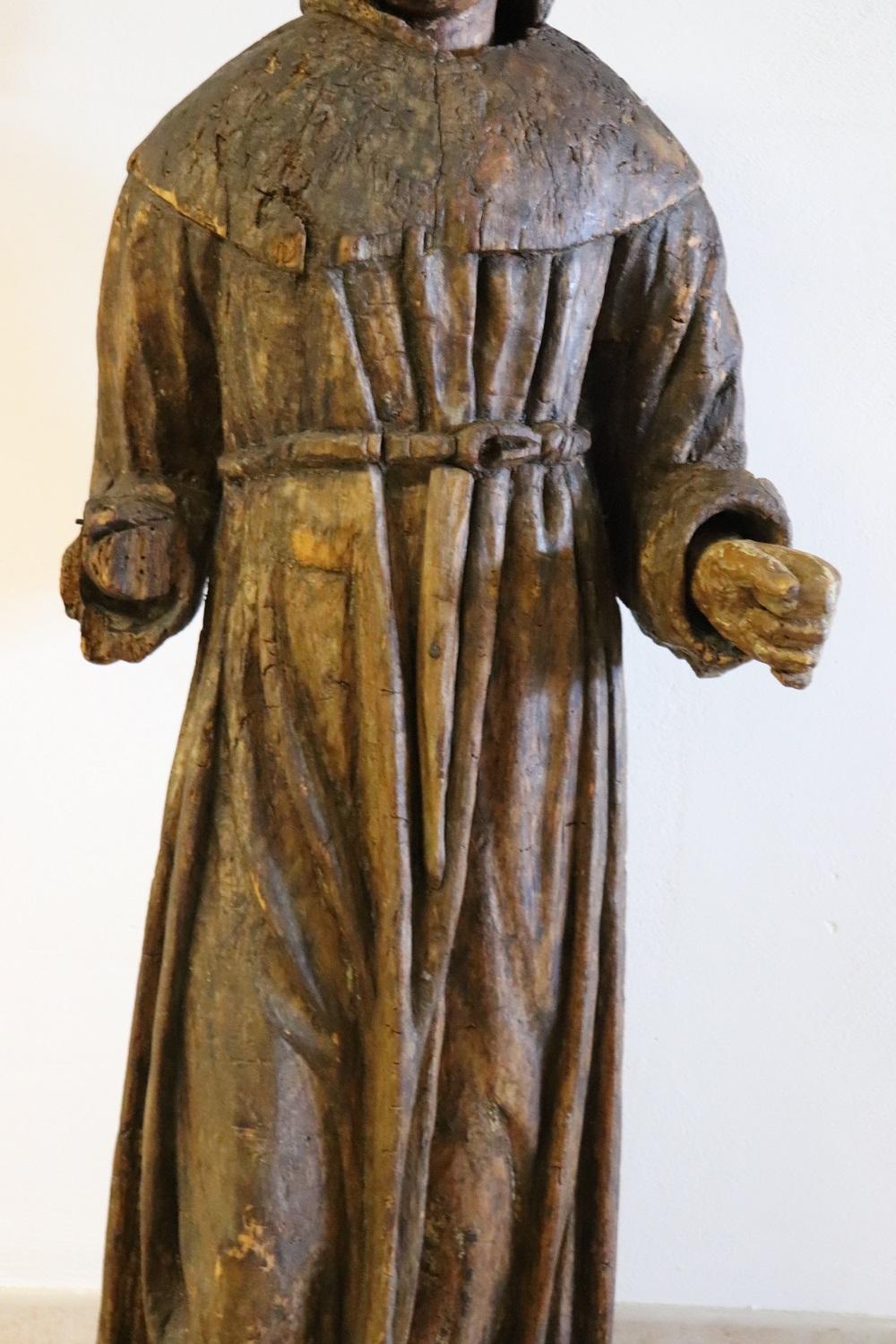 Rare antique italan wood sculpture, 17th century. Finely carved wooden work depicting a religious subject, a saint, identifiable with the figure of Saint Francis, of great size. The sculpture is made on each side to also be displayed in the center