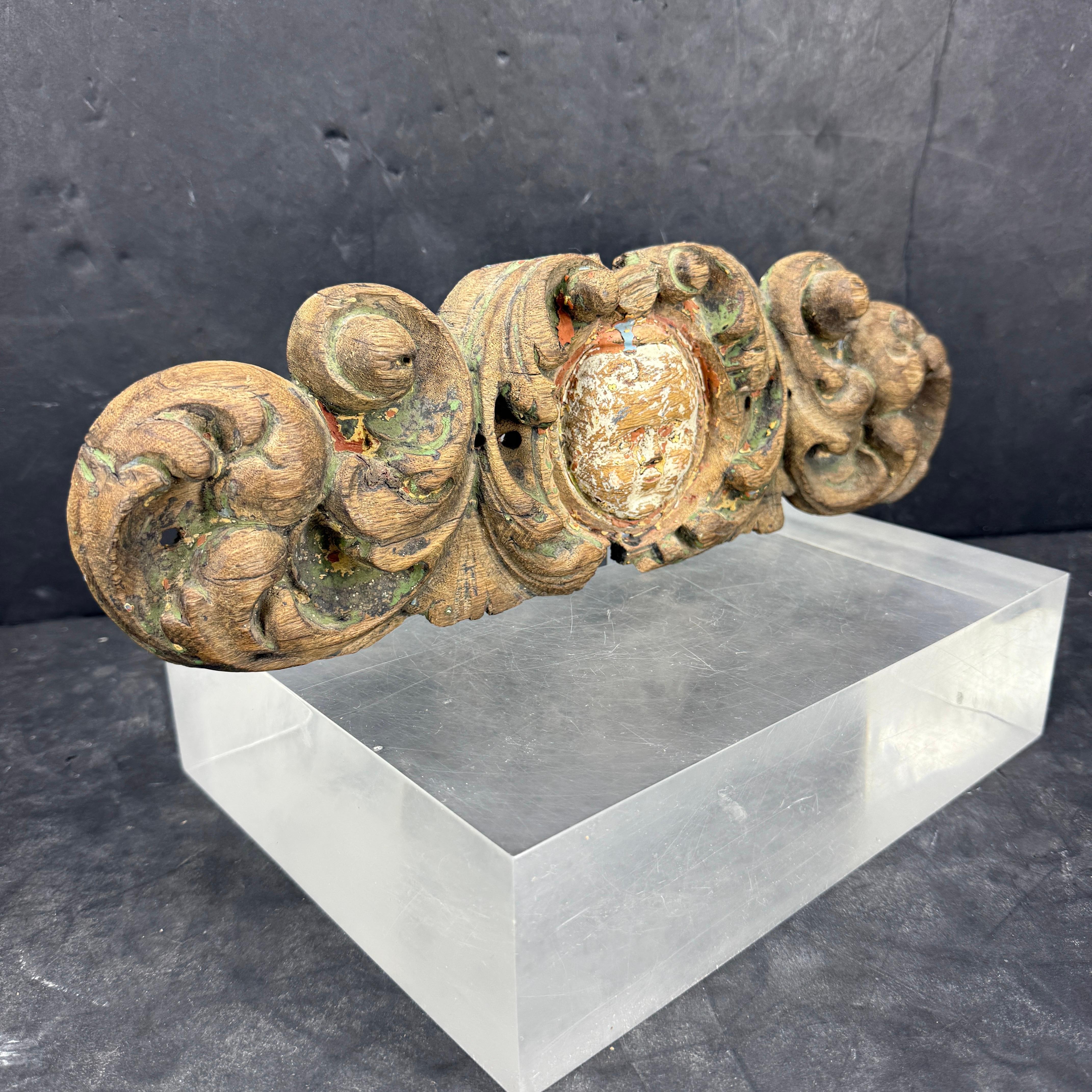 As found in Copenhagen, the beautiful period baroque designed wooden piece features intricate scroll motifs throughout as well as a cherub in the center. This hand carved piece retained some original paint and would be a wonderful architectural