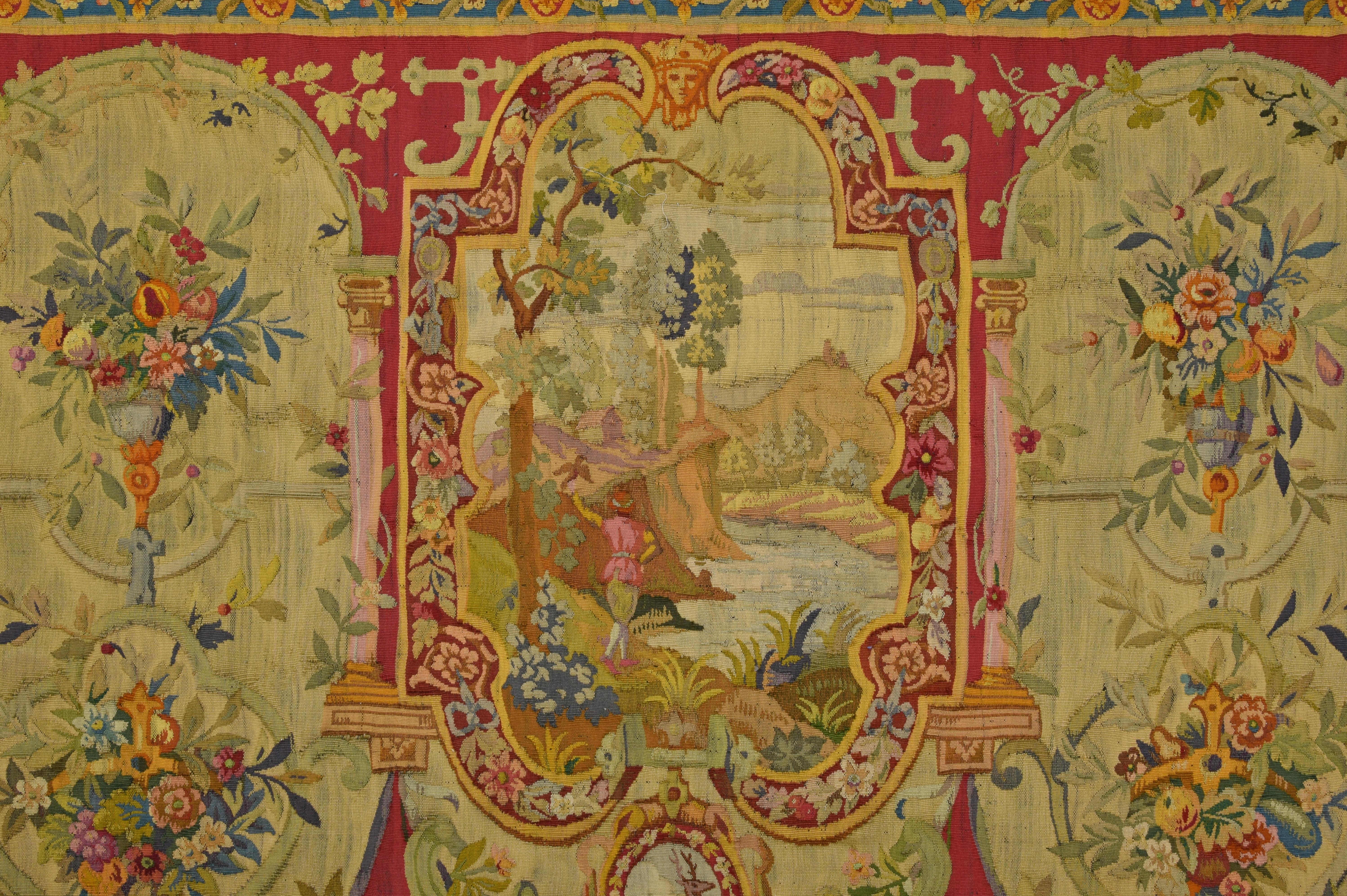 18th century wool tapestry with floral decorations and river landscape 

This large tapestry in wool was made in the Louis XV era, in the eighteenth century. It has a decoration inscribed inside a border with floral elements. The base is in red,