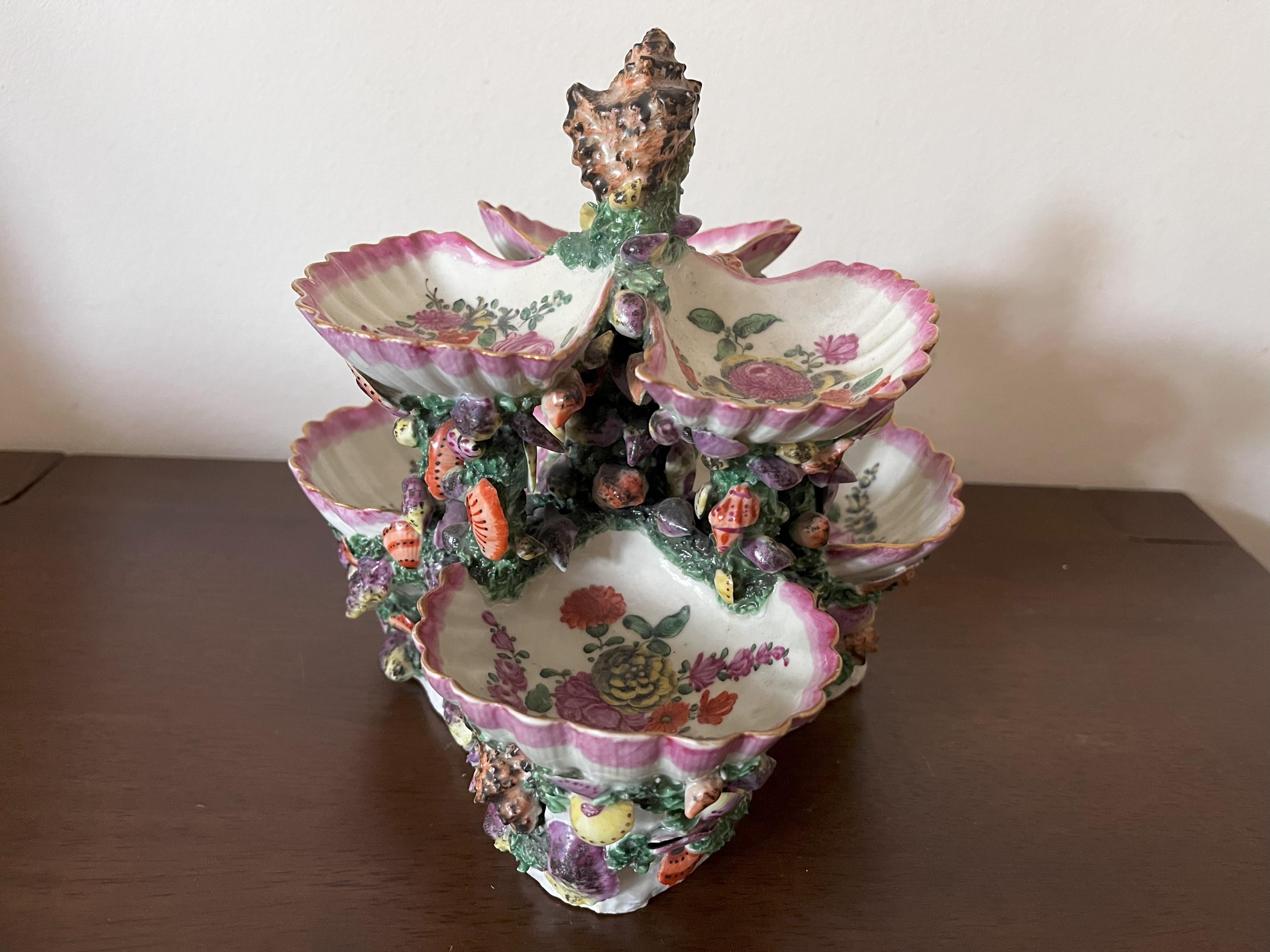 An 18th Century Worcester Porcelain Shell Centrepiece, circa 1770, naturalistically modelled as six shells on a base of smaller shells and coral, painted with flower sprays within pink borders.

This porcelain centrepiece was made at the Worcester