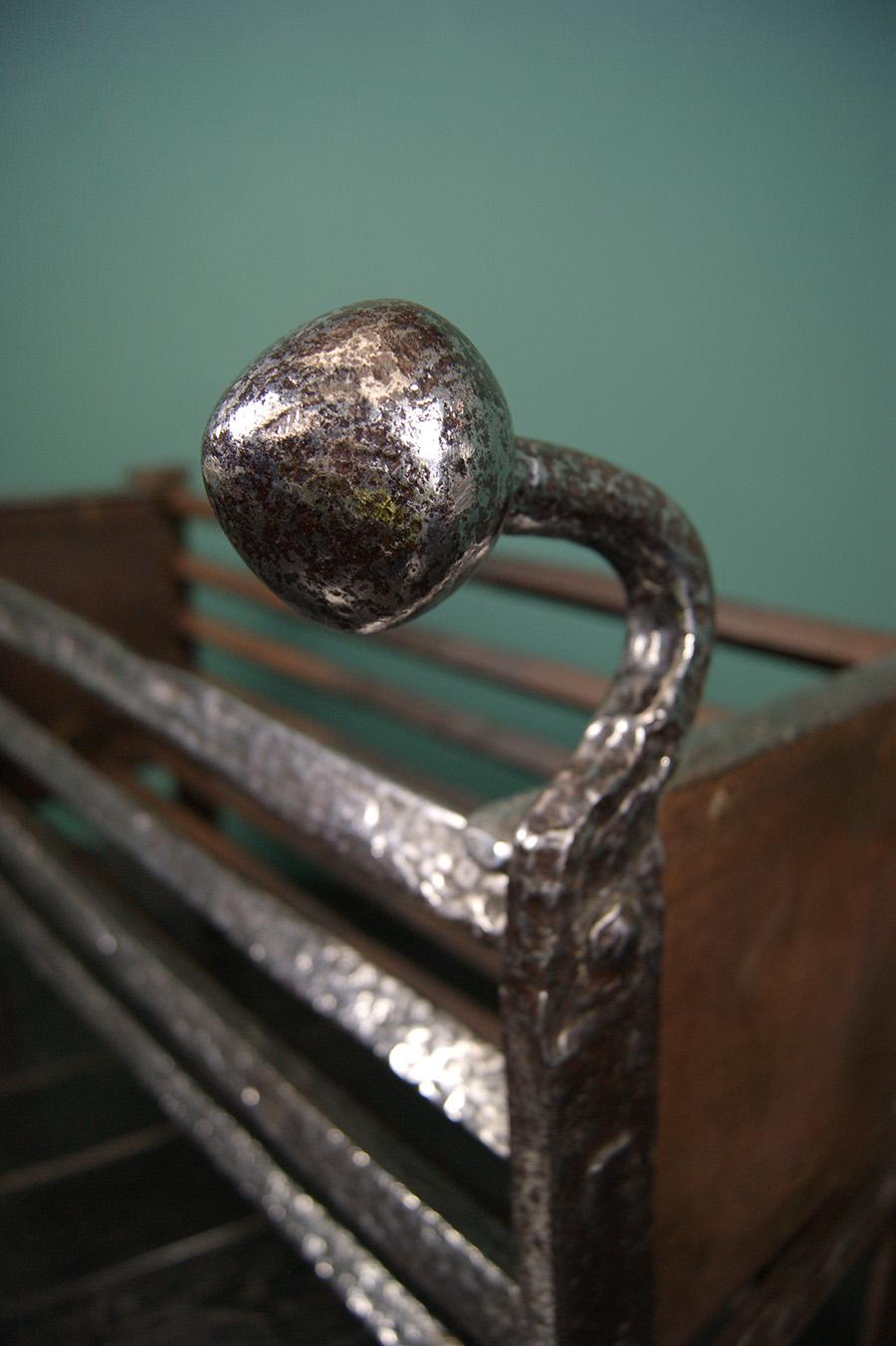 An 18th century polished wrought-iron fire basket with heavy rivet-work construction, side panels and bulbous finials. Restored. 
Height of burning area: 24cm
Circa 1790