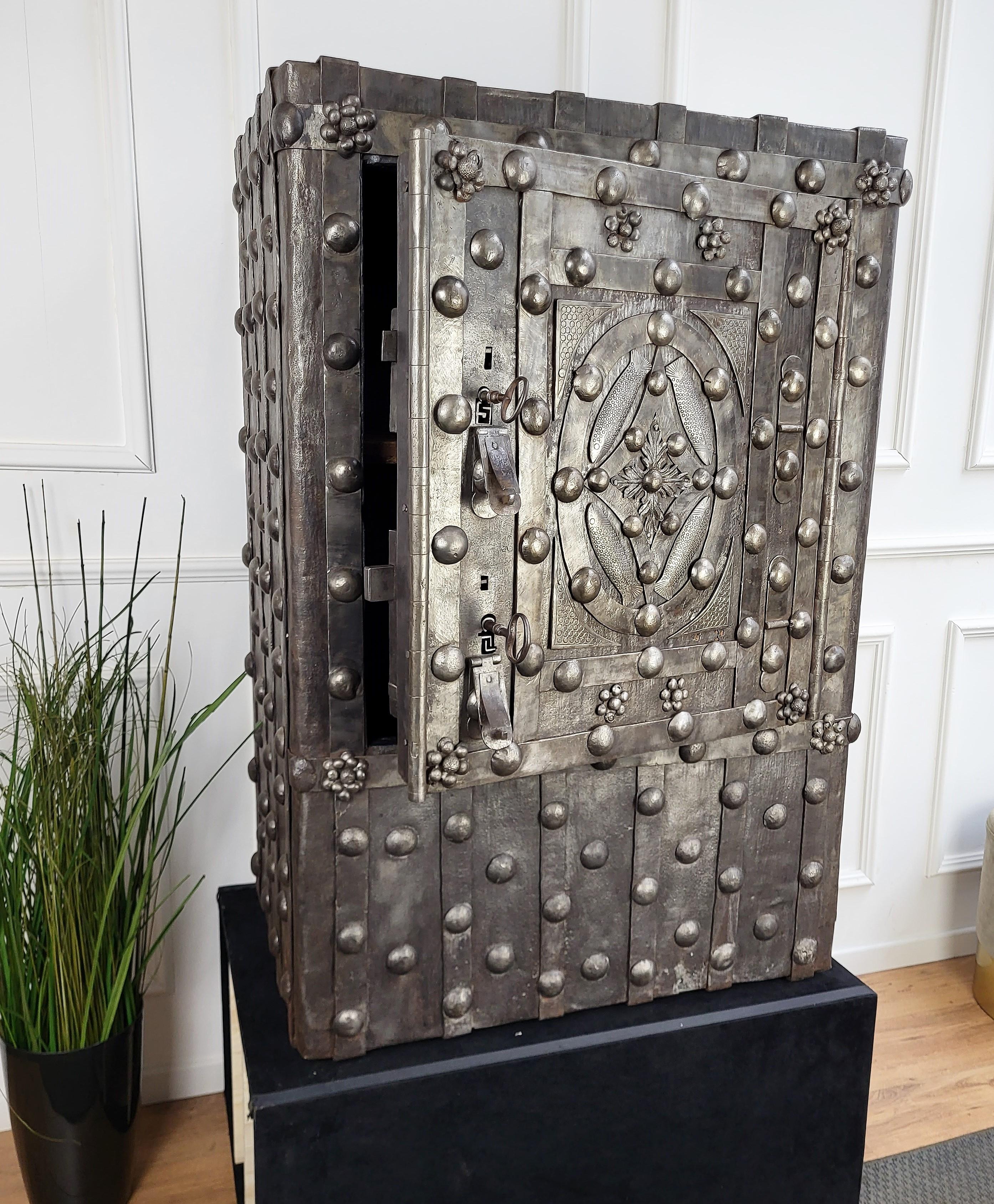 Beautiful and rare example of early 18th / late 17th Century Italian master blacksmith craftsmanship, this antique studded safe with typical all-around hobnails and great wrought iron details, has a fabulous central decor with the 4 fishes as well