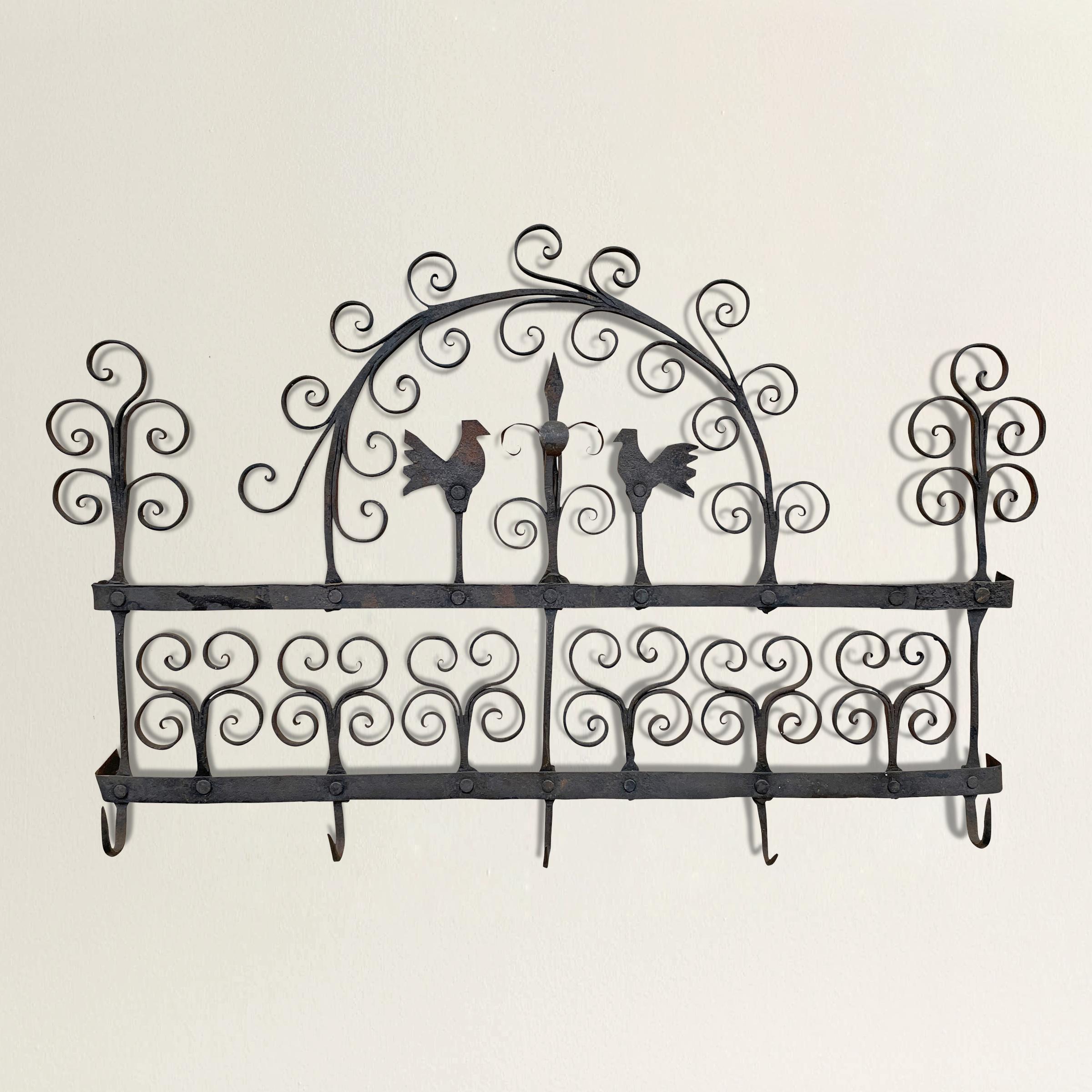 A charming 18th century hand-wrought iron kitchen rack with five hooks originally used for hanging spoons and other utensils near the hearth, and with two chickens and many wonderfully wrought curled stylized floral elements. We've had a custom