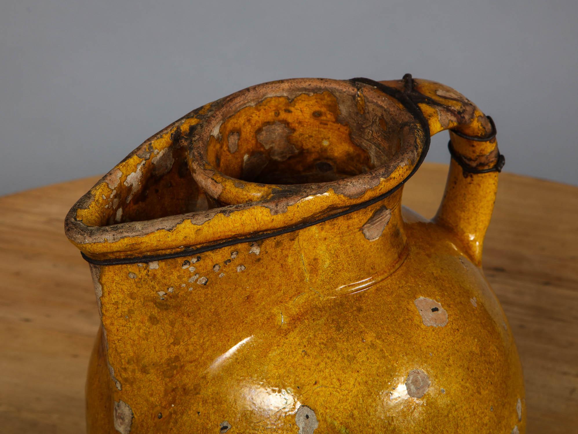Lovely yellow glazed 18th century harvest pitcher having iron wire reinforced handle/spout, good bulbous form and beautifully worn.