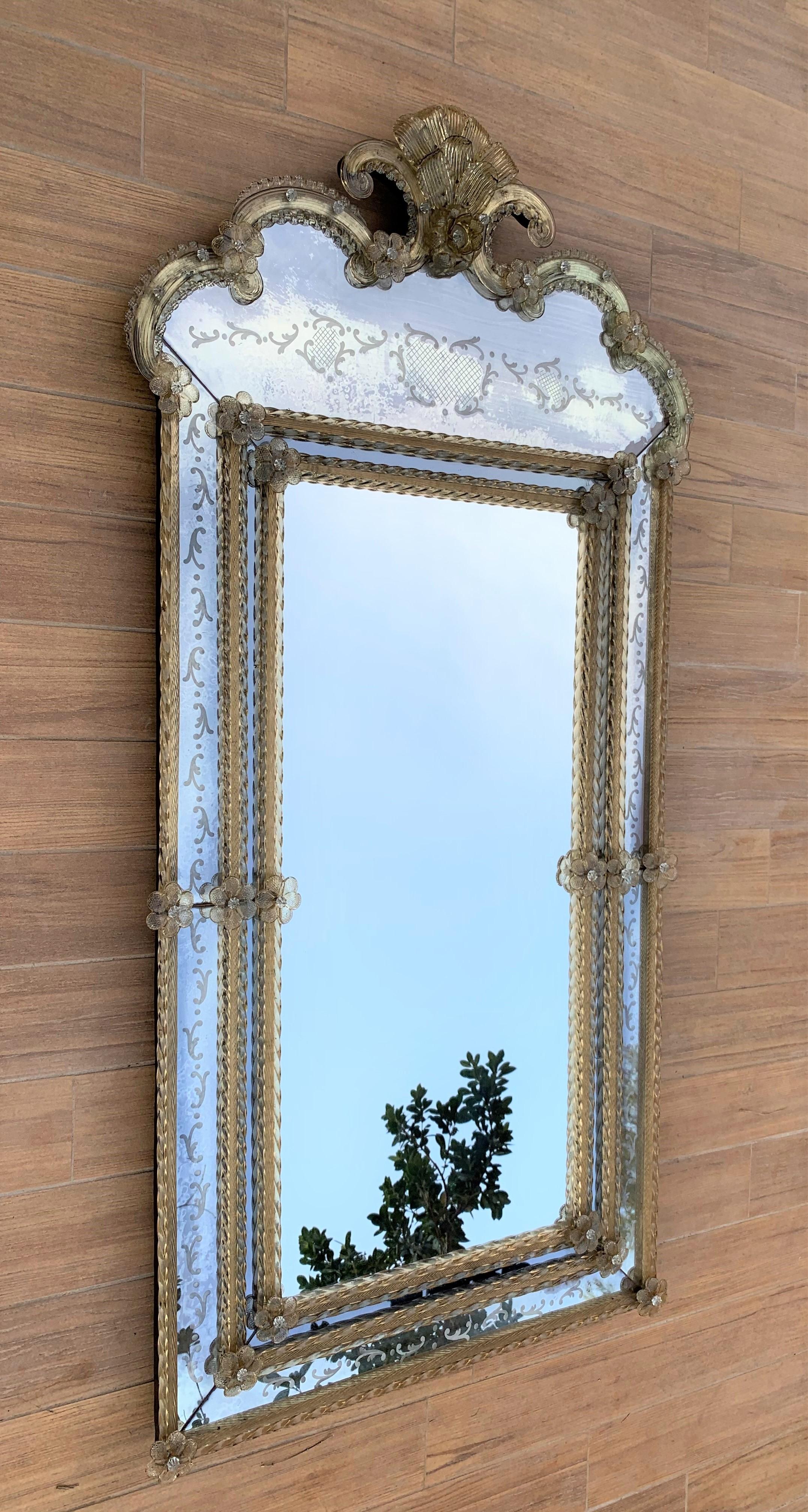 The crest top Venetian mirror. With its beveled panels and carved crest topped with a lovely lotus flower-like motif, the crest top mirror has been handmade and hand silvered. The central panel shows a light antiquing finish while the surround has a