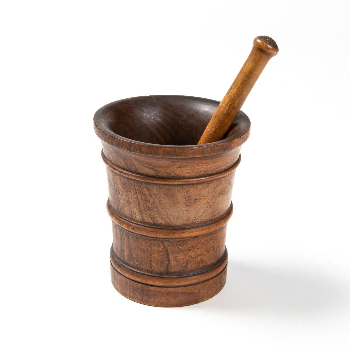 Un élégant mortier et pilon ancien, finement travaillé en bois dur tropical, très probablement du pachyloba, avec un grain riche et une patine chaude.
Il reste en excellent état d'origine.
Mesures	H : 22  Dia : 19 cm  Pilon H : 30 cm
Matériau	Bois