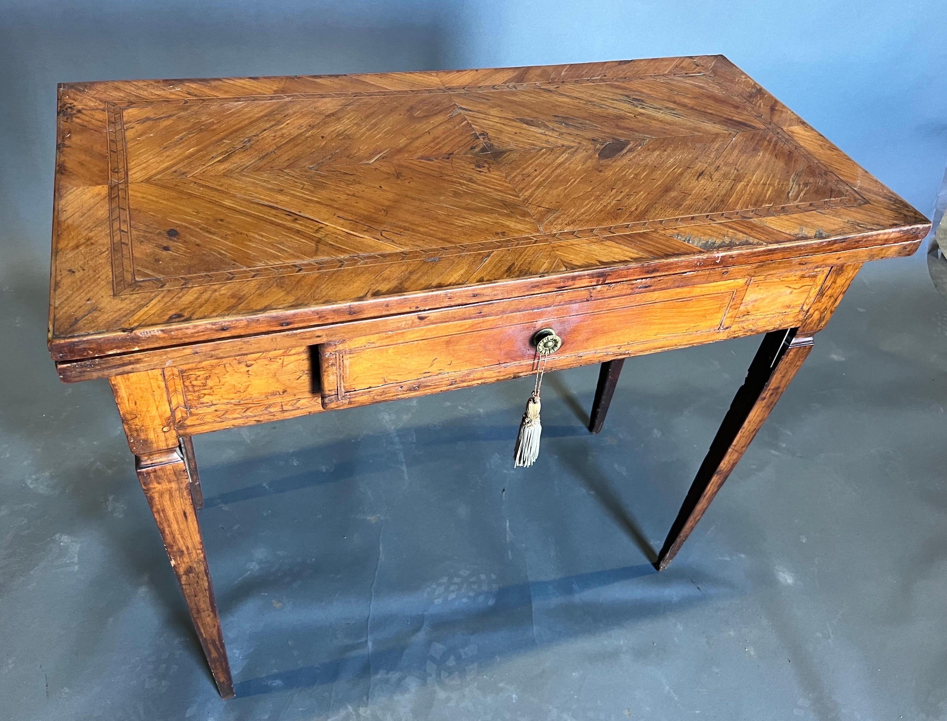 Attractive Late 18th century Italian neoclassical inlaid games table with double swing back legs to fold over top. Great color and quality walnut veneers.