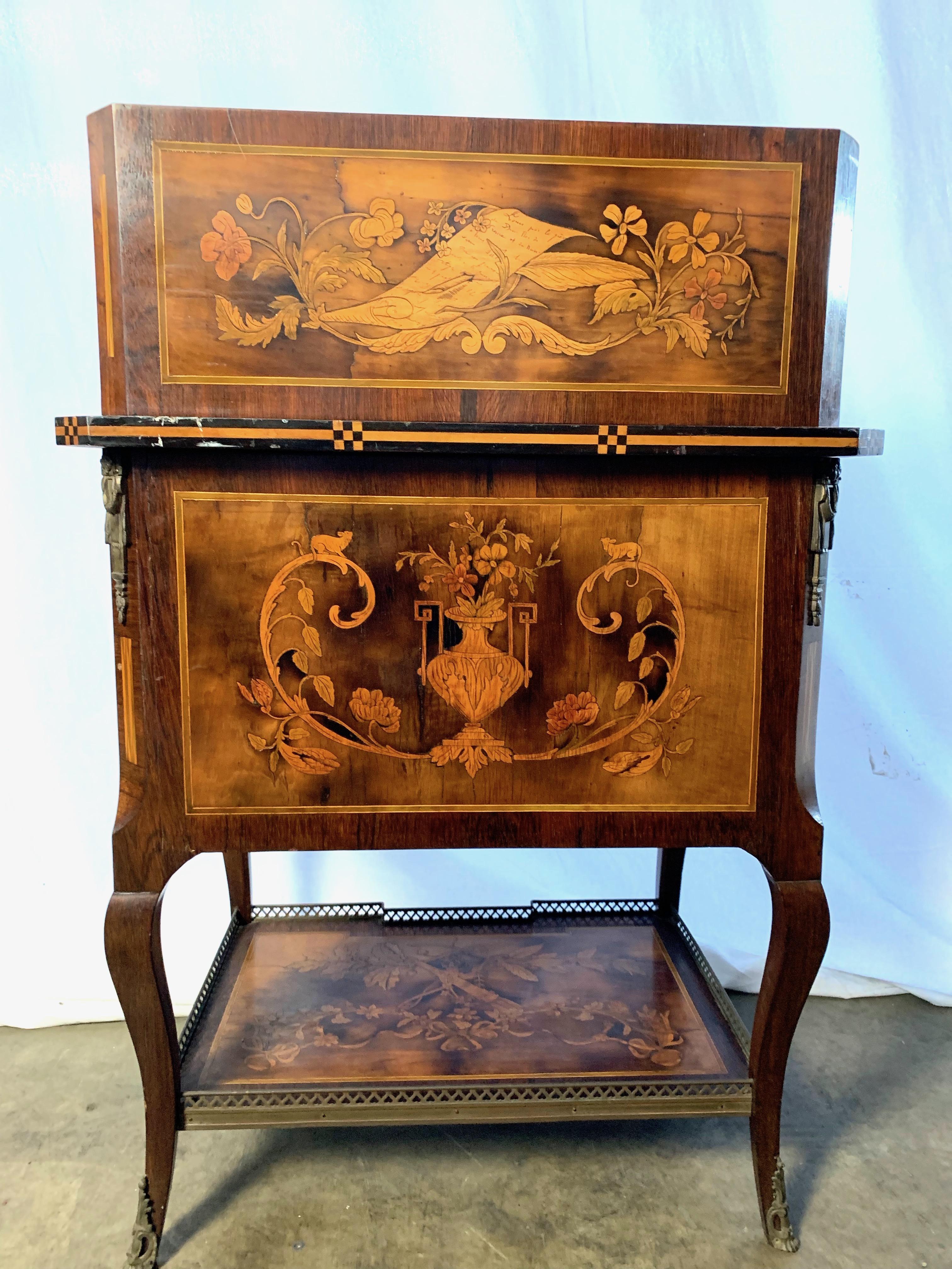 A French satinwood and marquetry inlaid Bonheure du Jour, late 18th century. The upper portion consisting of six deep drawers all above a single frieze drawer and tambour slide cupboard opening to reveal further inlaid drawers centered by a small