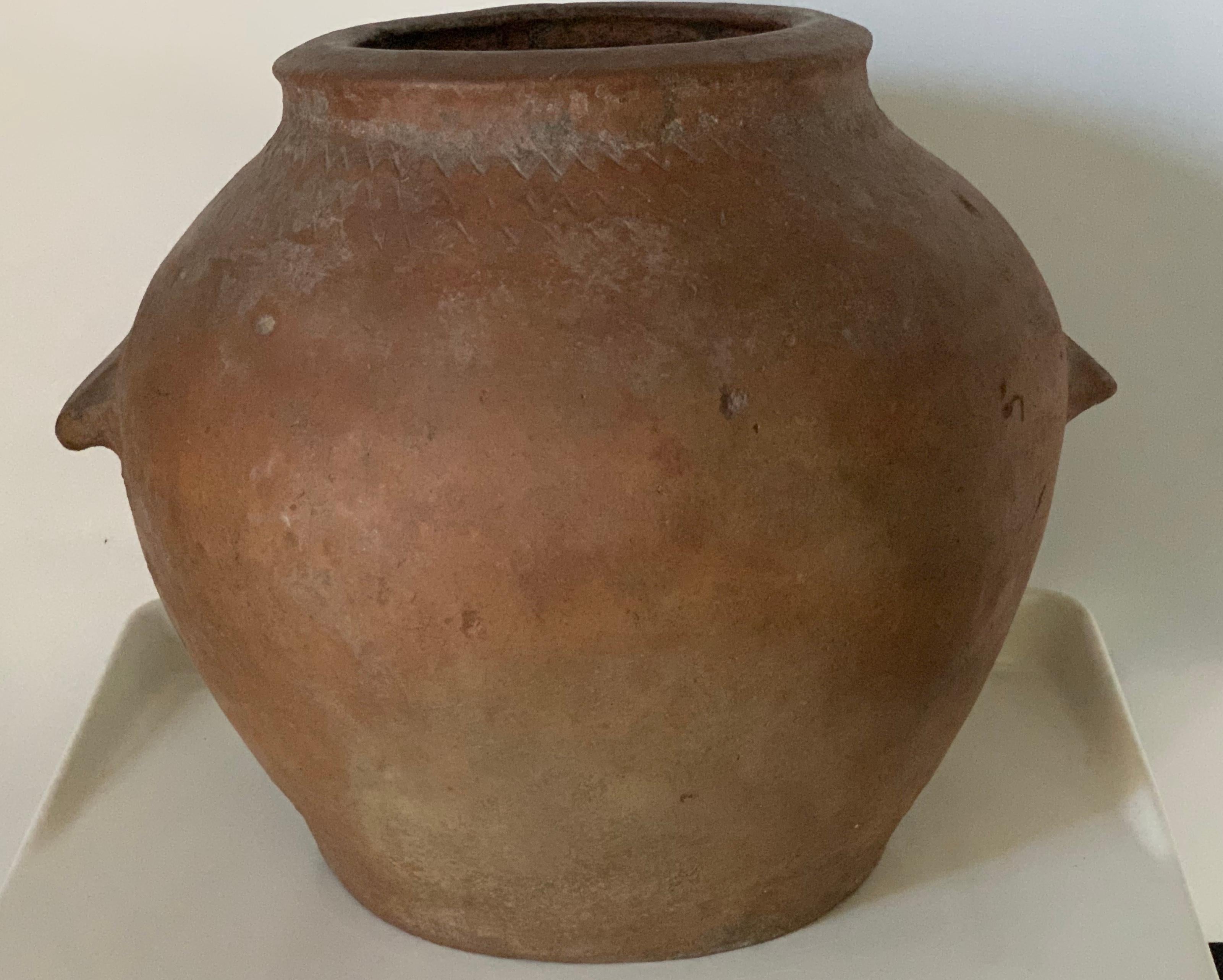 This is a terracotta olive jar from central Spain. It has a wonderful aged patina with chalky painted finish. It makes a great statement as a sculpture in a room on a pedestal, alone or with a plant. Stamped on the pot and two handmande