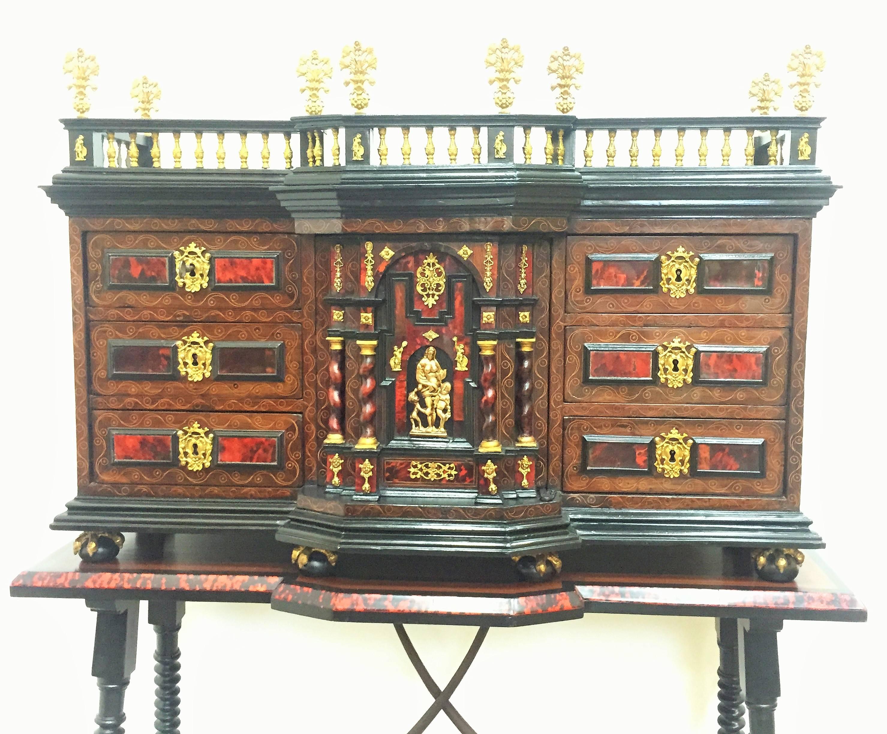 Italian cabinet on table. Walnut and rosewood, hawksbill, bronze in color and gilded, 17th century.
Sample desktop pool located on ball and claw with handles on the sides. The front features the advanced central chapel; and four drawers each side;