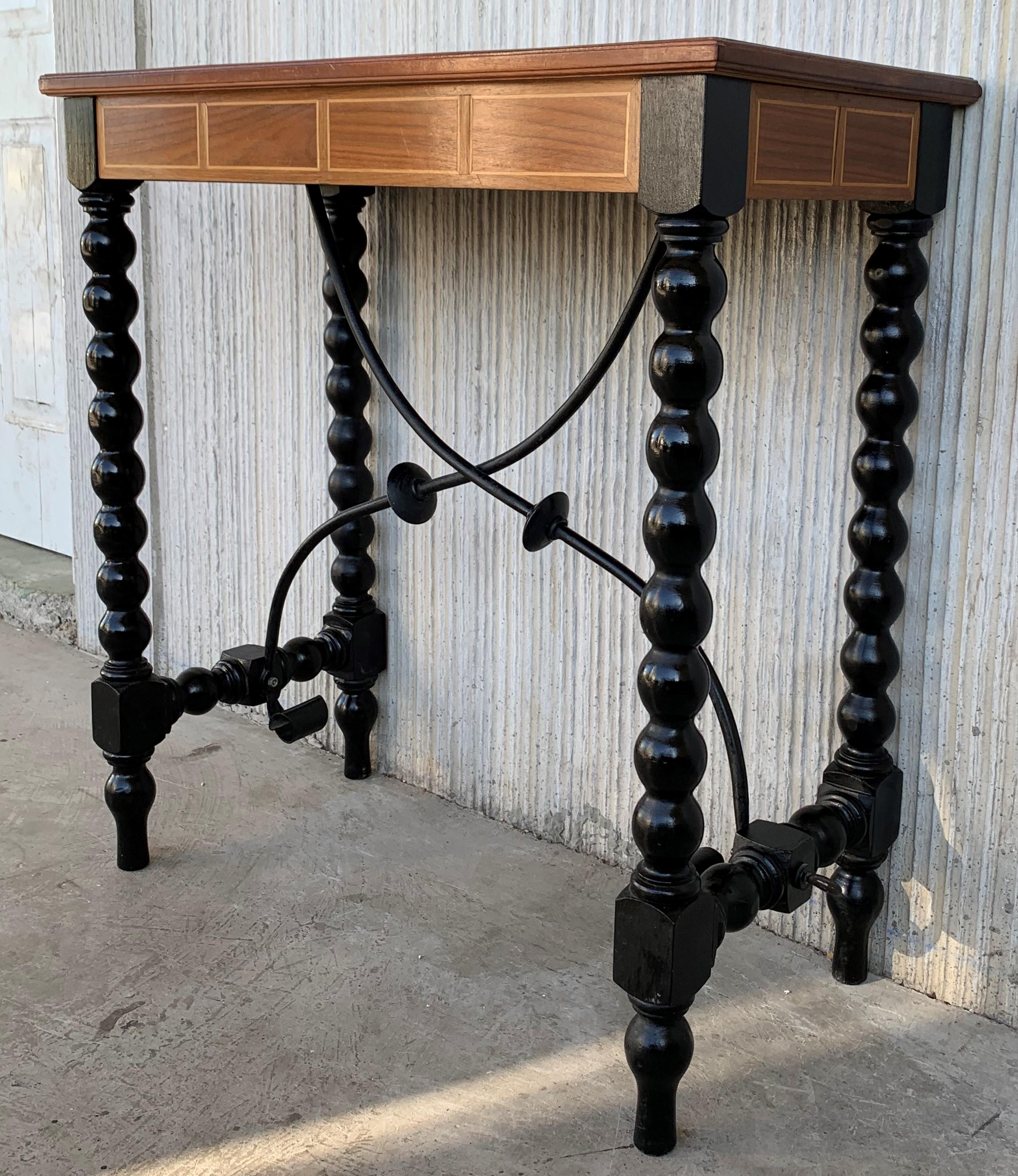 18th century Spanish console table with beautiful marquetry top with geometrical figures and black ebonized lentil legs. The legs are joined by an iron stretcher with rare disk shaped finished.