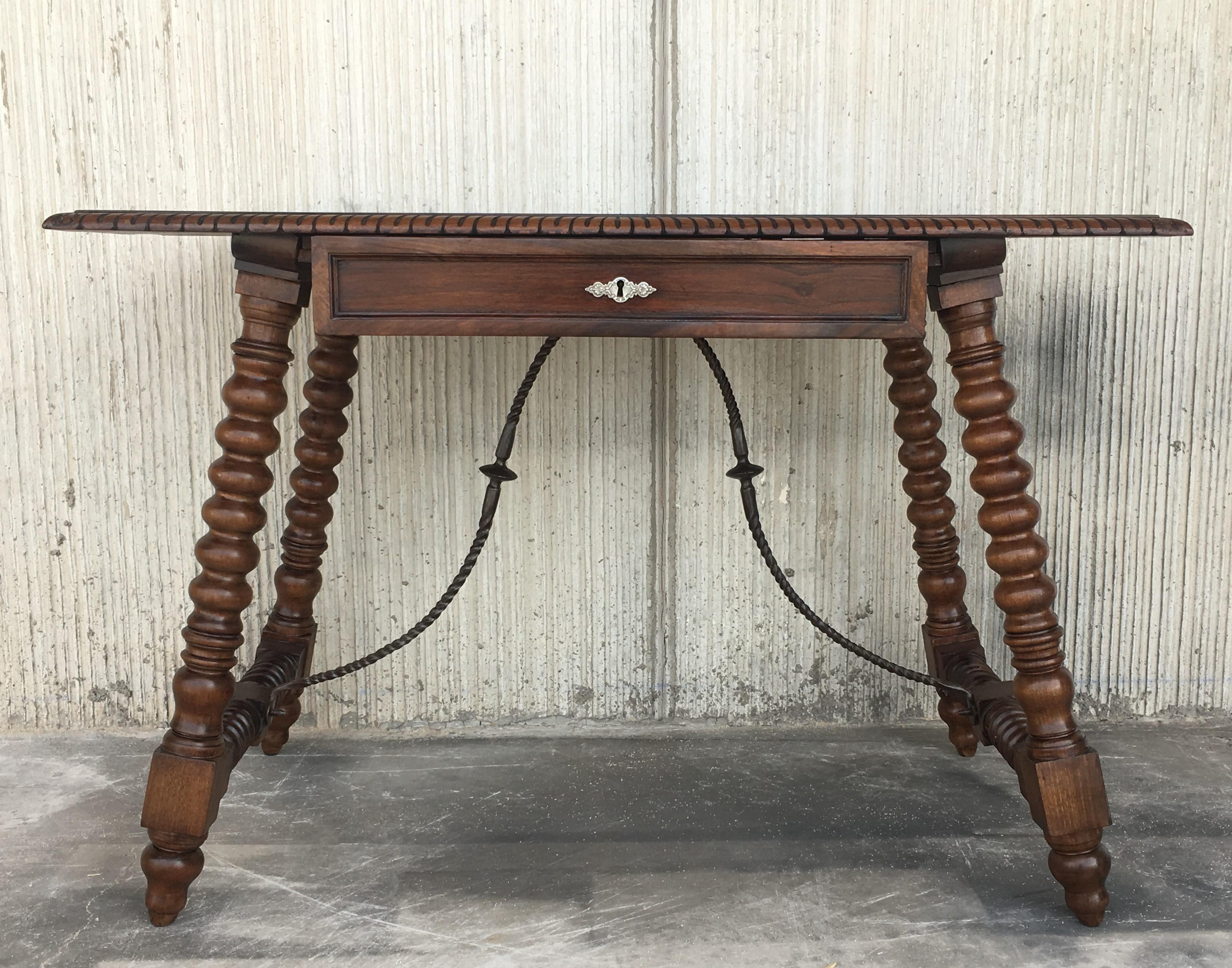 Refectory writing table, of walnut, having a rectangular top, over single frieze drawer, raised on bobbin-turned legs, joined by iron stretcher, on bun feet.