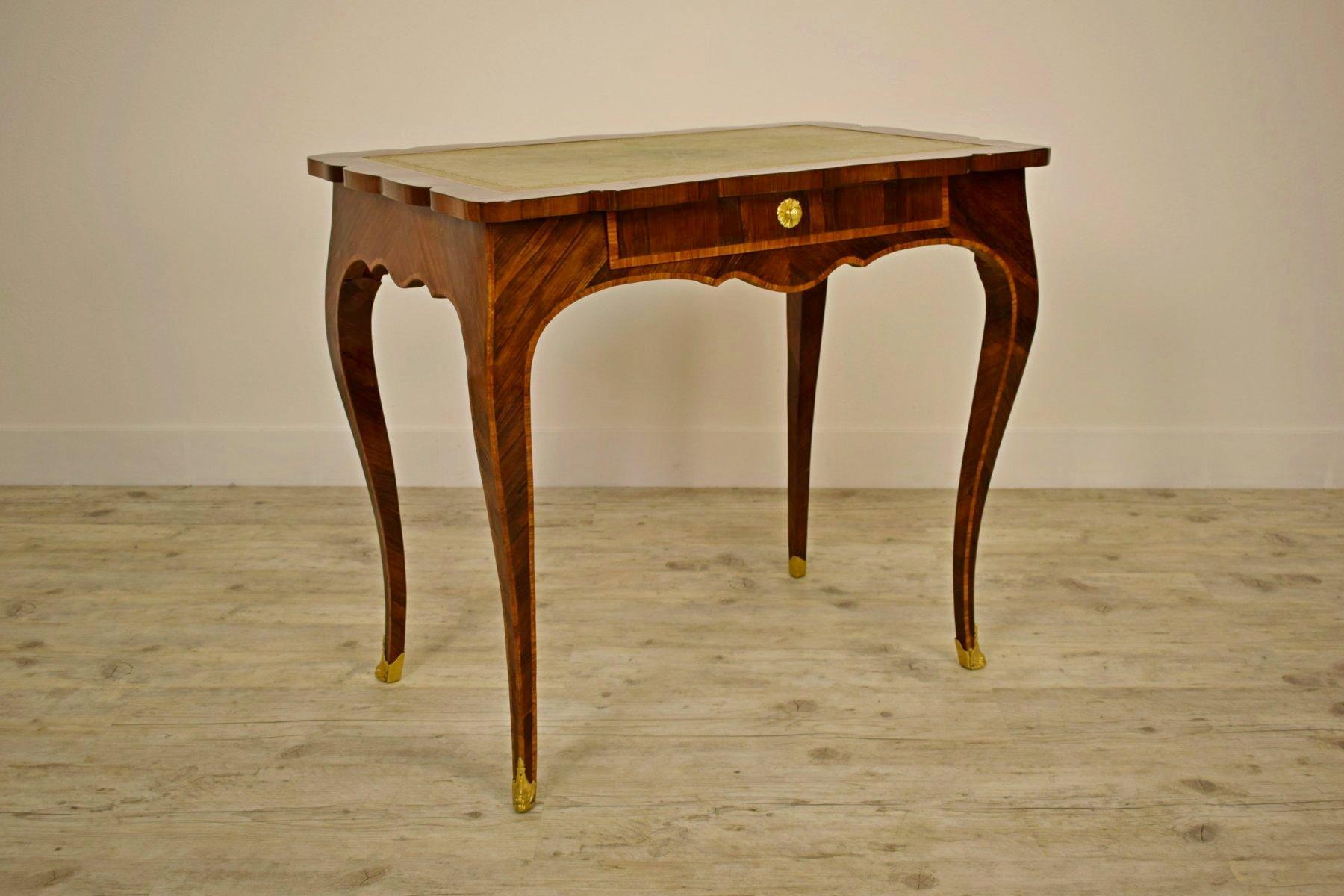 L'élégant bureau d'écriture d'époque Louis XV de l'Italie du Nord (Gênes), appelé aussi bureau plat, est réalisé en bois plaqué et marqueté. Il a une belle ligne ondulée avec des jambes fines mais solides. Les pupitres ont un élégant cuir