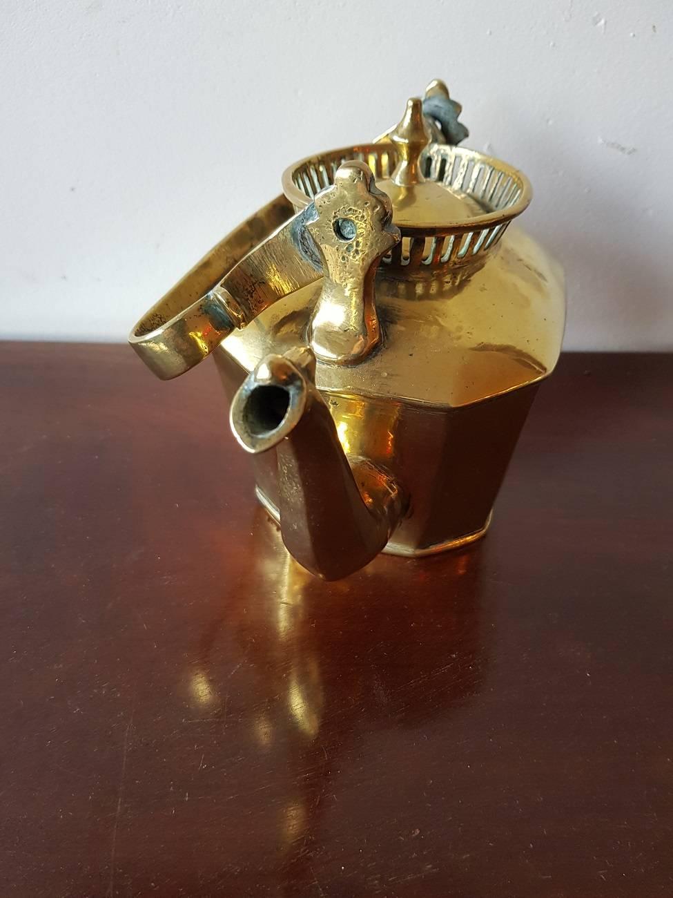 18th-19th century probably Dutch or English tea kettle made of cast brass except the bottom that is soldered into it and a heavy one for it's small size.

The measurements are:
Depth 12 cm/ 4.7 inch.
Width 21 cm/ 8.2 inch.
Height 15 cm/ 5.9