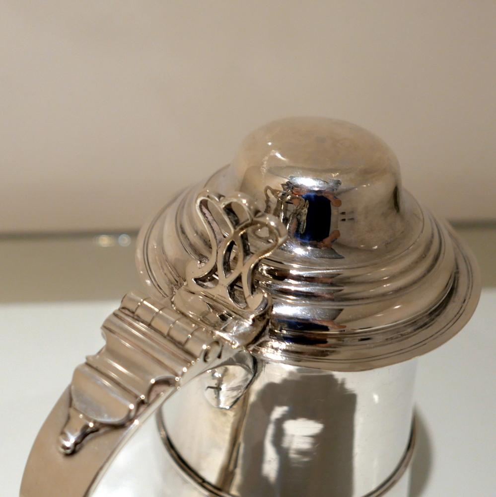 A highly collectable Georgian baluster tankard and cover made by the renowned lady silversmith Hester Bateman 18th century. The tankard is plain formed in design with just an elegant strap work band for decoration. The centre front of the body has a