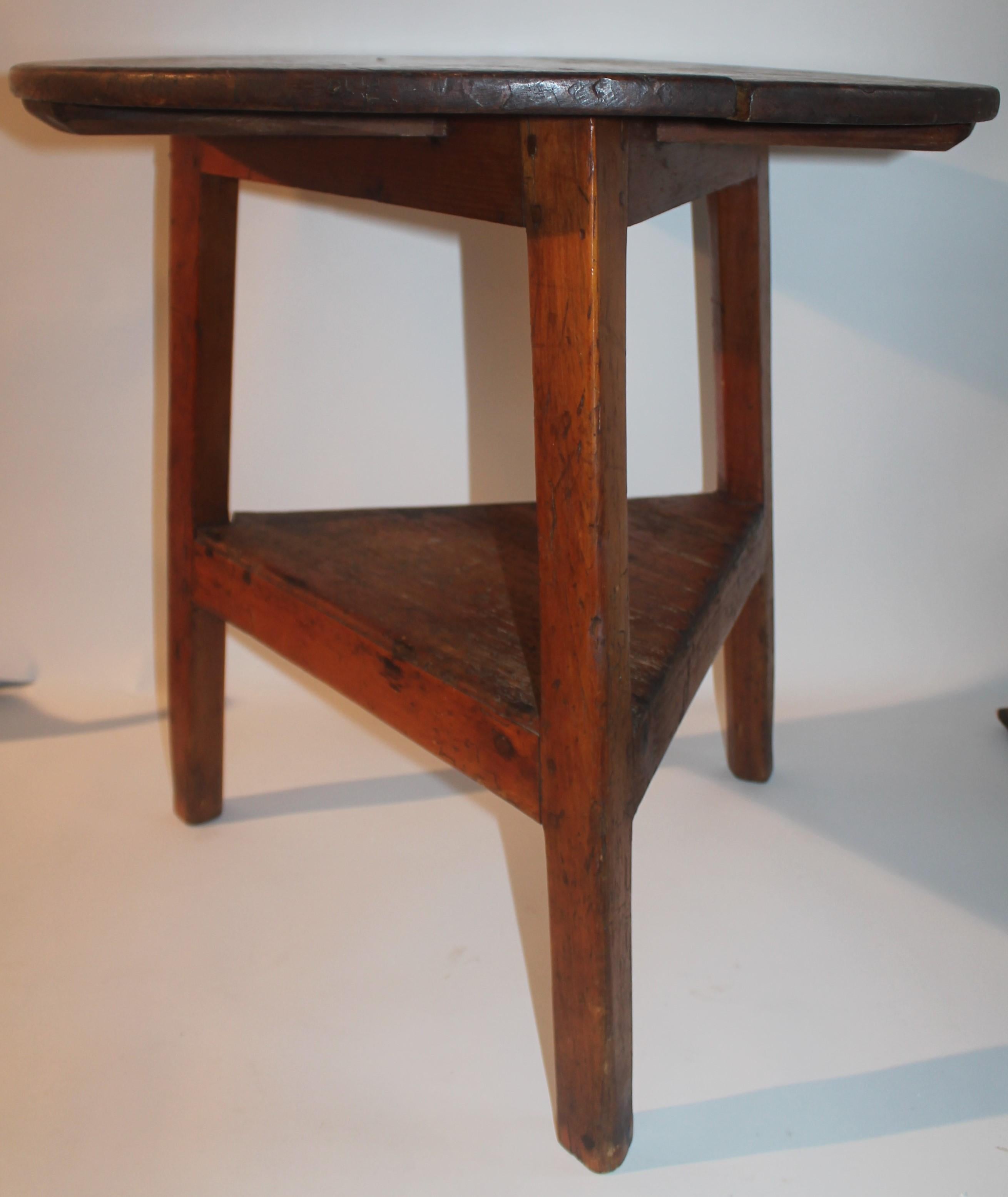18thc cricket table from New England in fantastic condition. This three leg pine side table is in fine condition. It is constructed of cut nails & wood pegs. Wonderful aged patina.