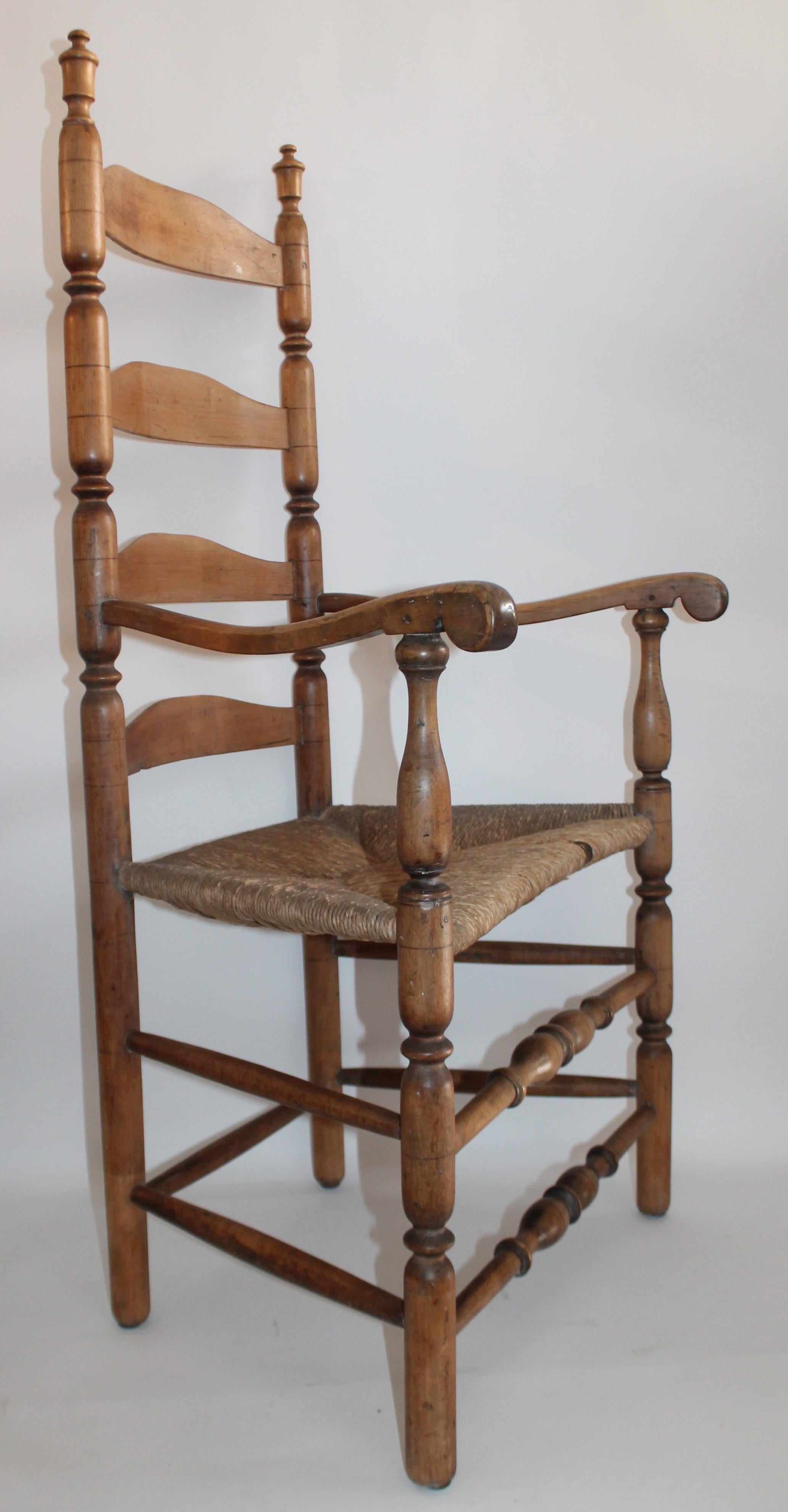 18th century New England Ladder back armchair with original rush seat. Fantastic undisturbed surface with worn arms. Super comfortable and in nice condition. Great western look with Navajo Indian weaving's. All hand carved turnings.