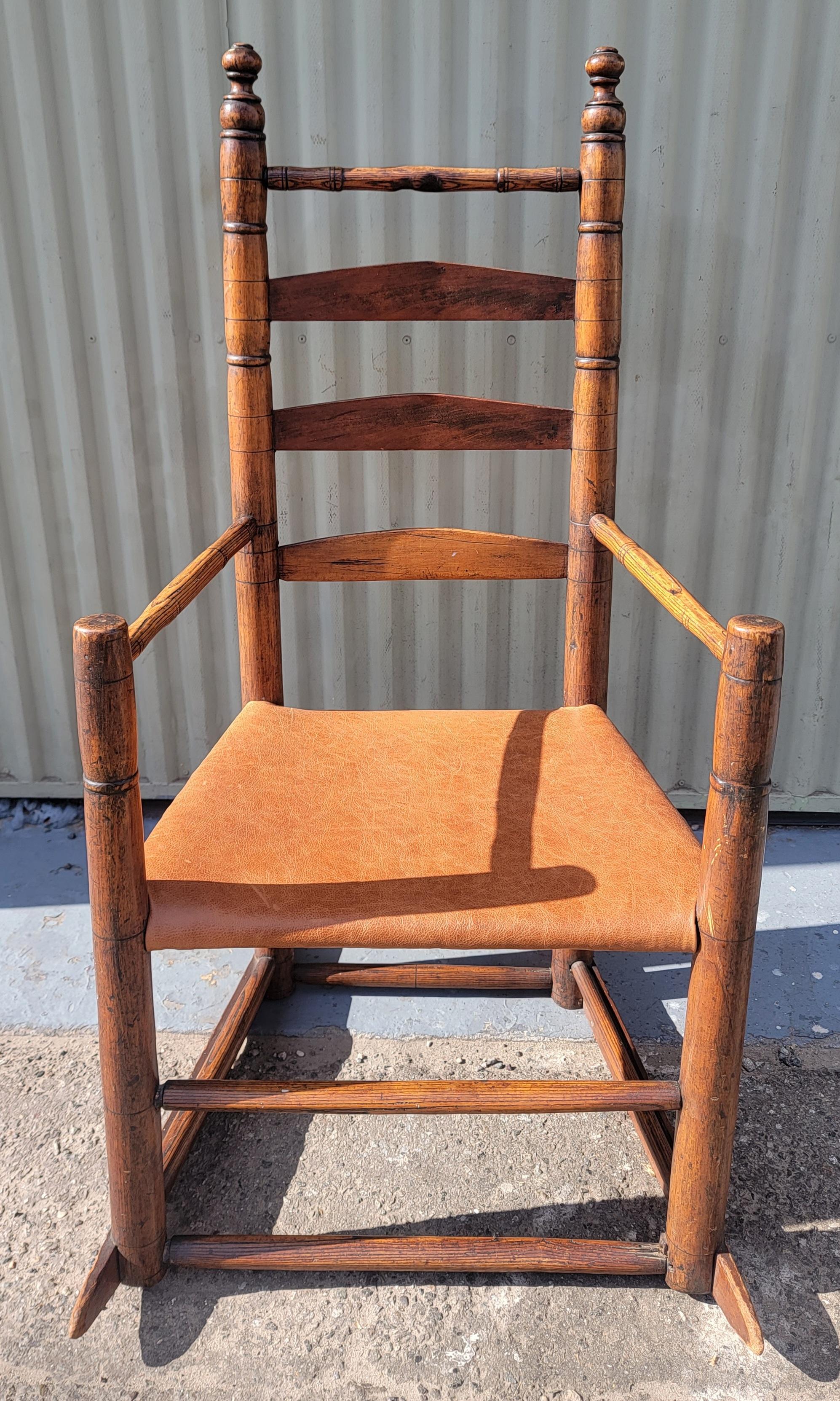 18Thc New England ladder back rocking chair in fine condition.This chair has an amazing replaced tan leather seat in fine condition.