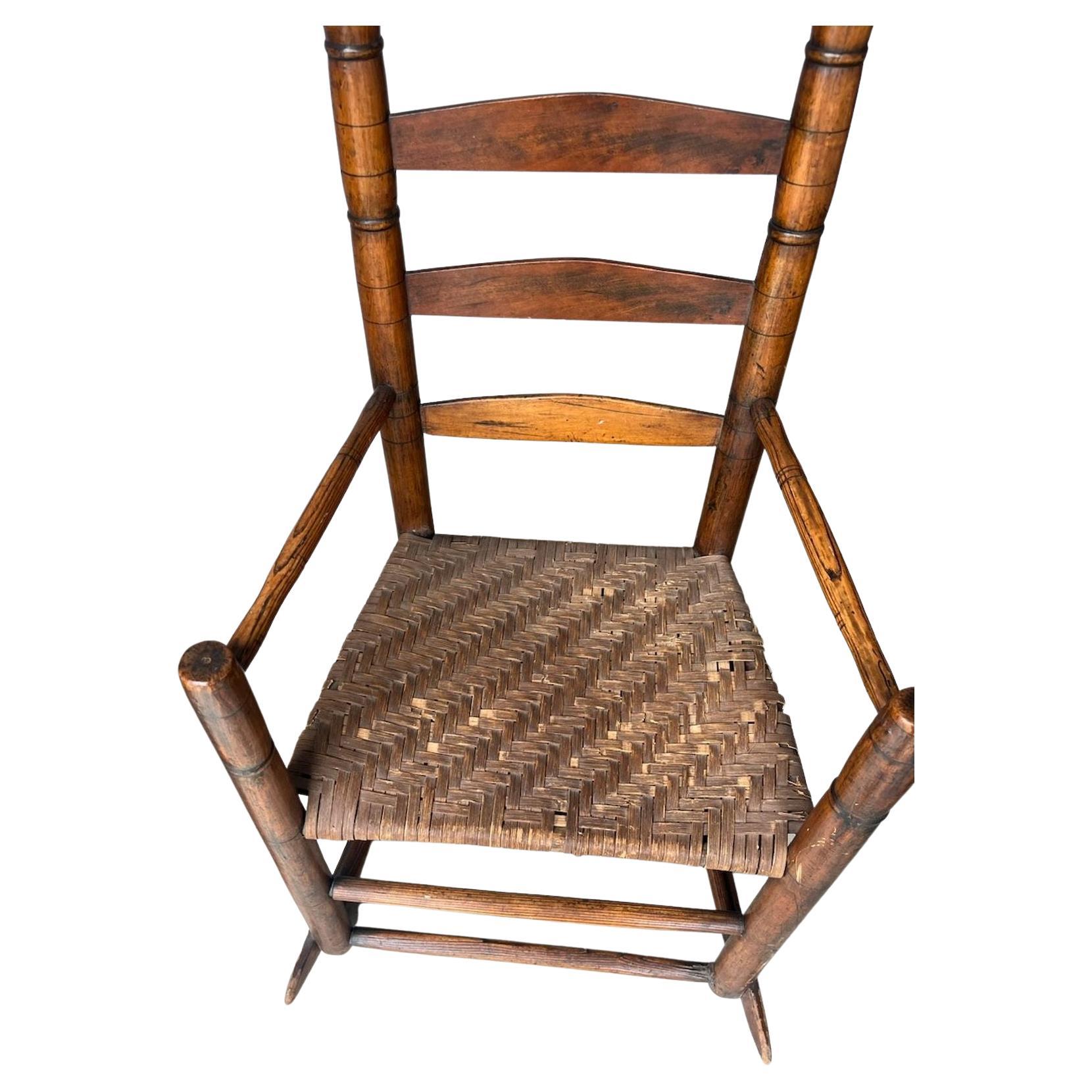 Chaise à bascule de la Nouvelle Angleterre, dossier en fuseau, ancienne et usée, avec une patine magnifique. Cette chaise à bascule a été trouvée dans une succession du Maine et est en bon état.
