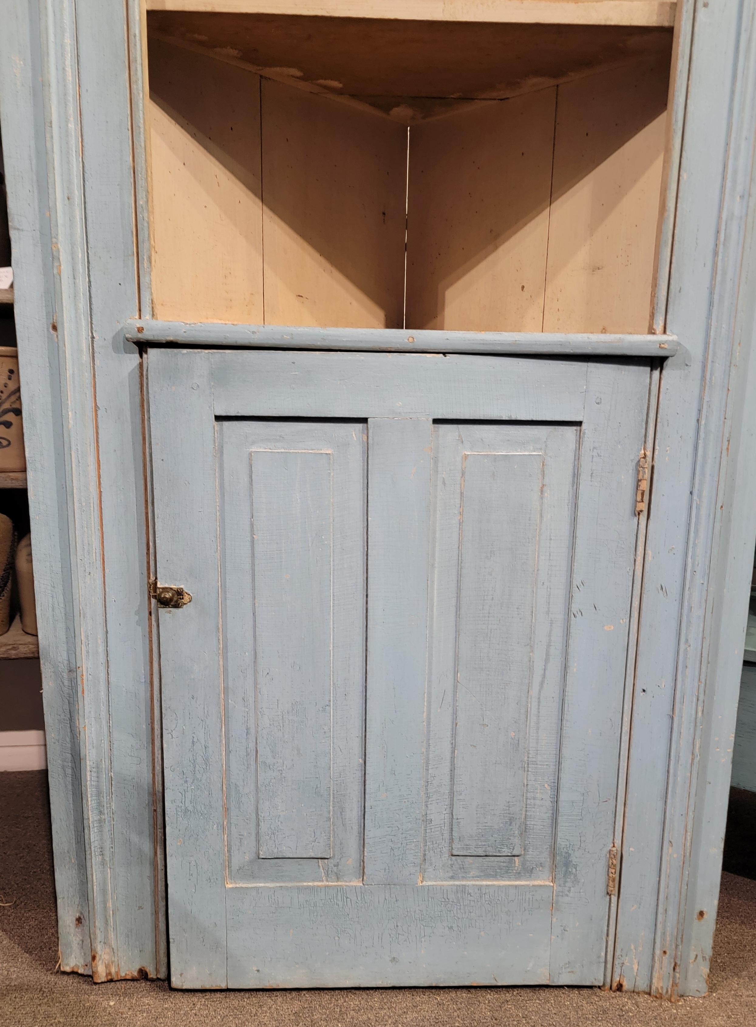 18Thc Original powder blue paneled narrow corner cupboard with picture frame molding.The original cram colored interior original painted interior is undisturbed and amazing patina.The construction is wood pegs and early cut nails.
